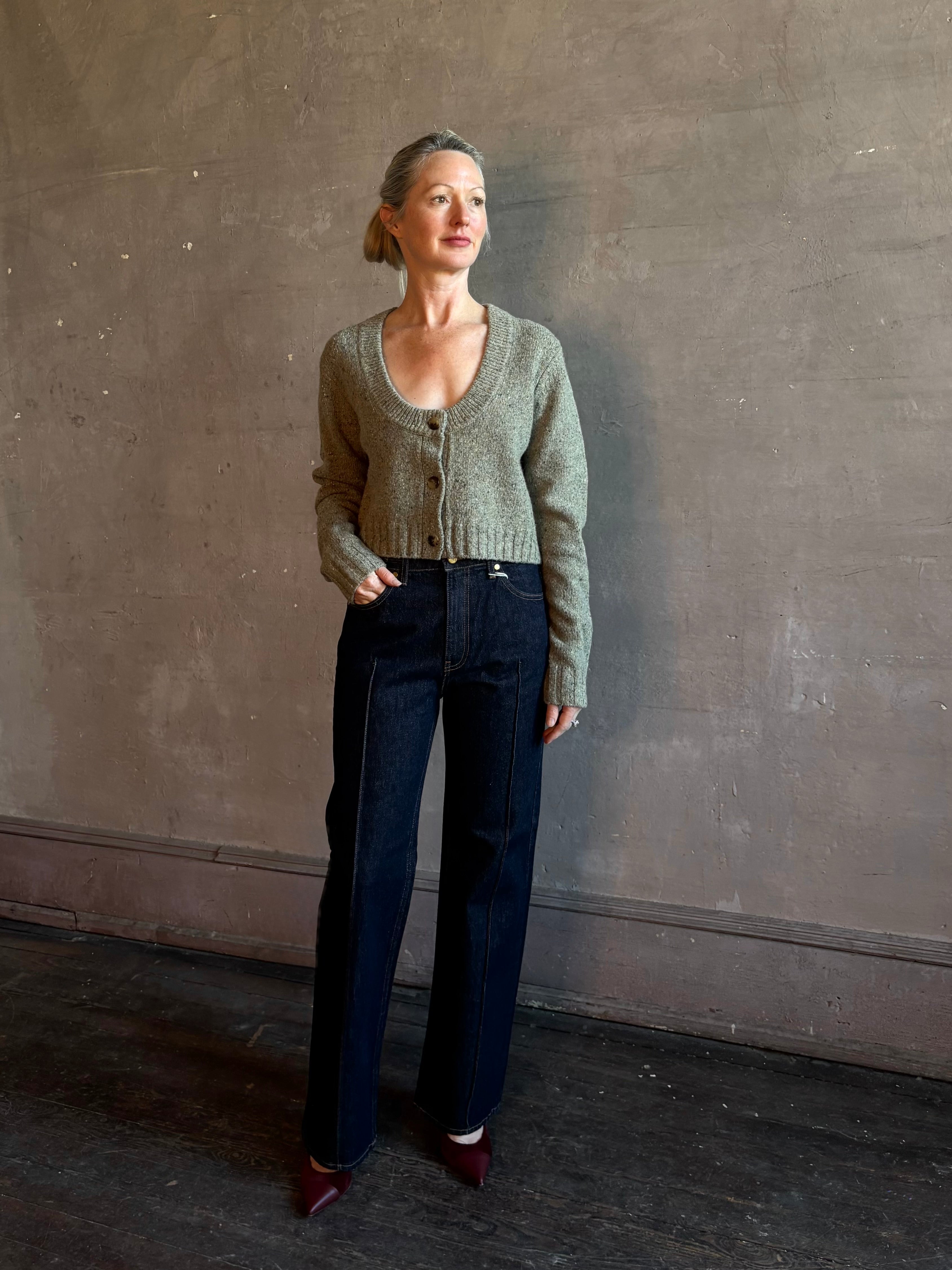 Mature woman wearing Rachel Comey Uridge Cardigan in Stone Green RWS-certified merino blend with U-neckline everyday layering