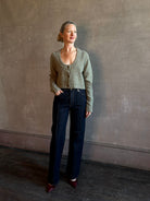 Mature woman wearing Rachel Comey Uridge Cardigan in Stone Green RWS-certified merino blend with U-neckline everyday layering