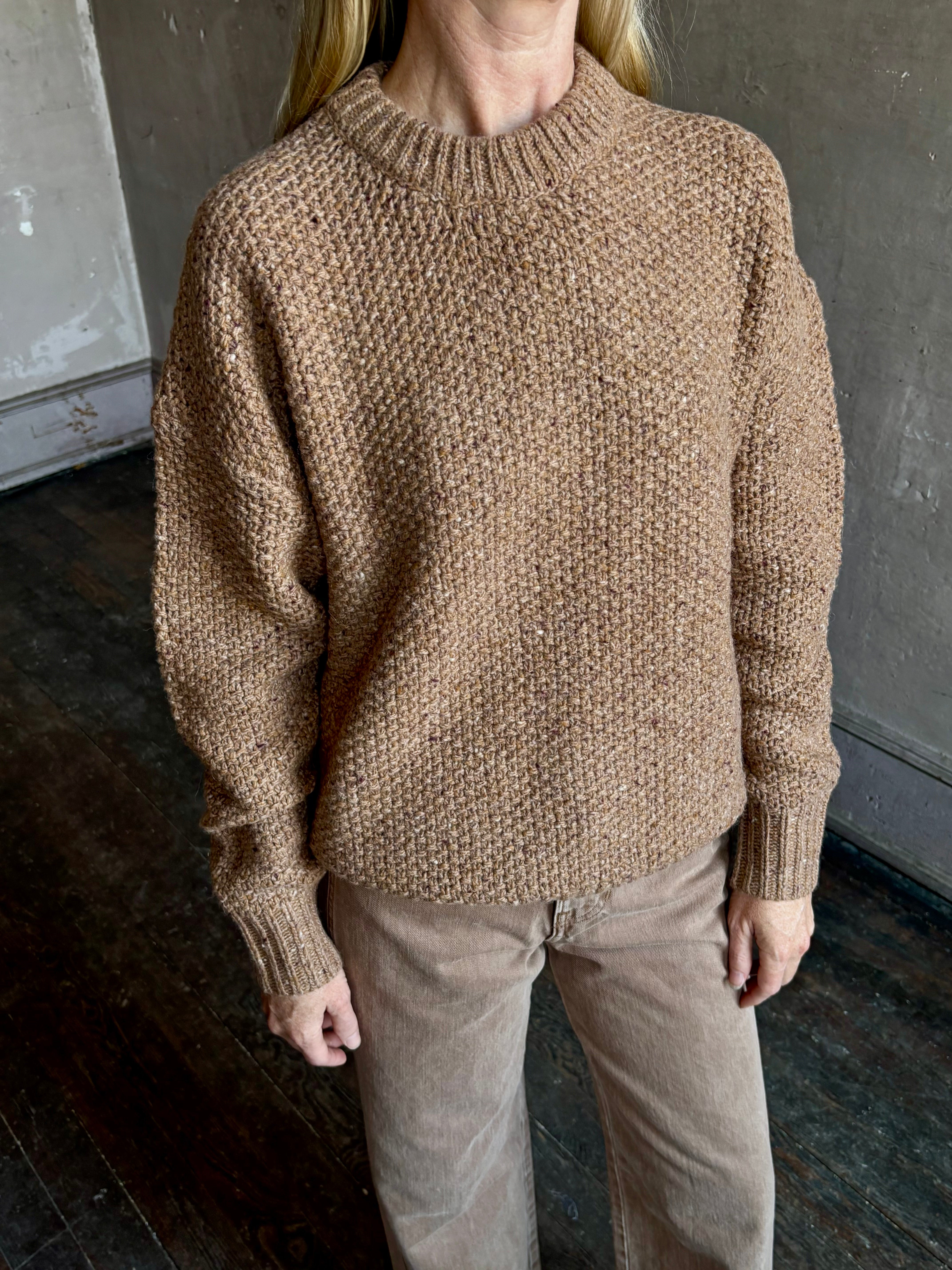 Image of mature woman wearing American designer Rachel Comey prescot sweater in a warm neutral colorway made with fine merino wool