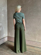Mature woman  wearing a textured short-sleeve fitted knit top in sage green round neckline with brown heathering