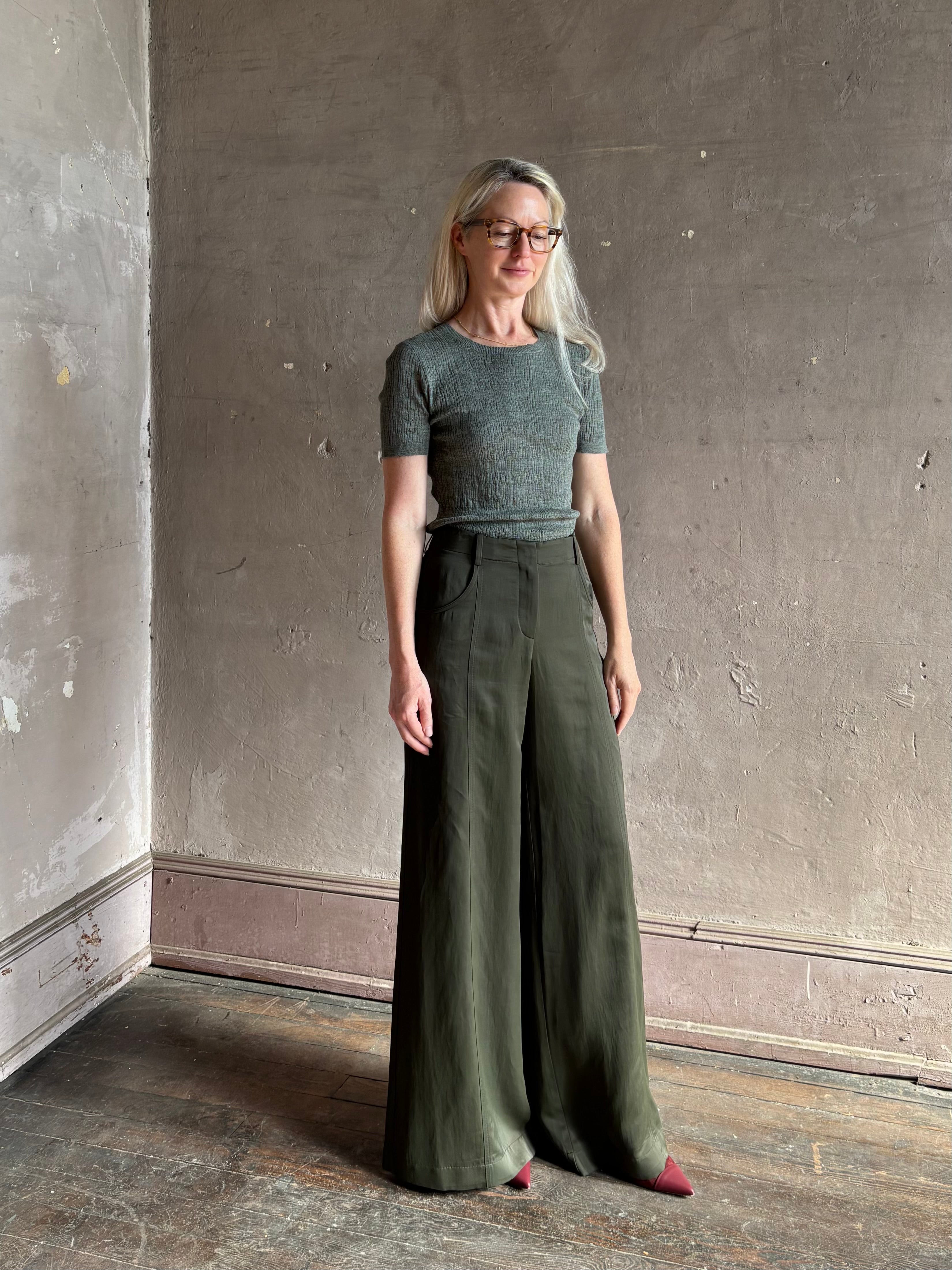 Mature woman  wearing a textured short-sleeve fitted knit top in sage green round neckline with brown heathering