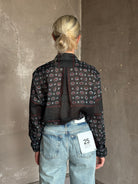 Mature woman wearing designer brand Rachel Comey long sleeve paisley print button down shirt semi-transparent