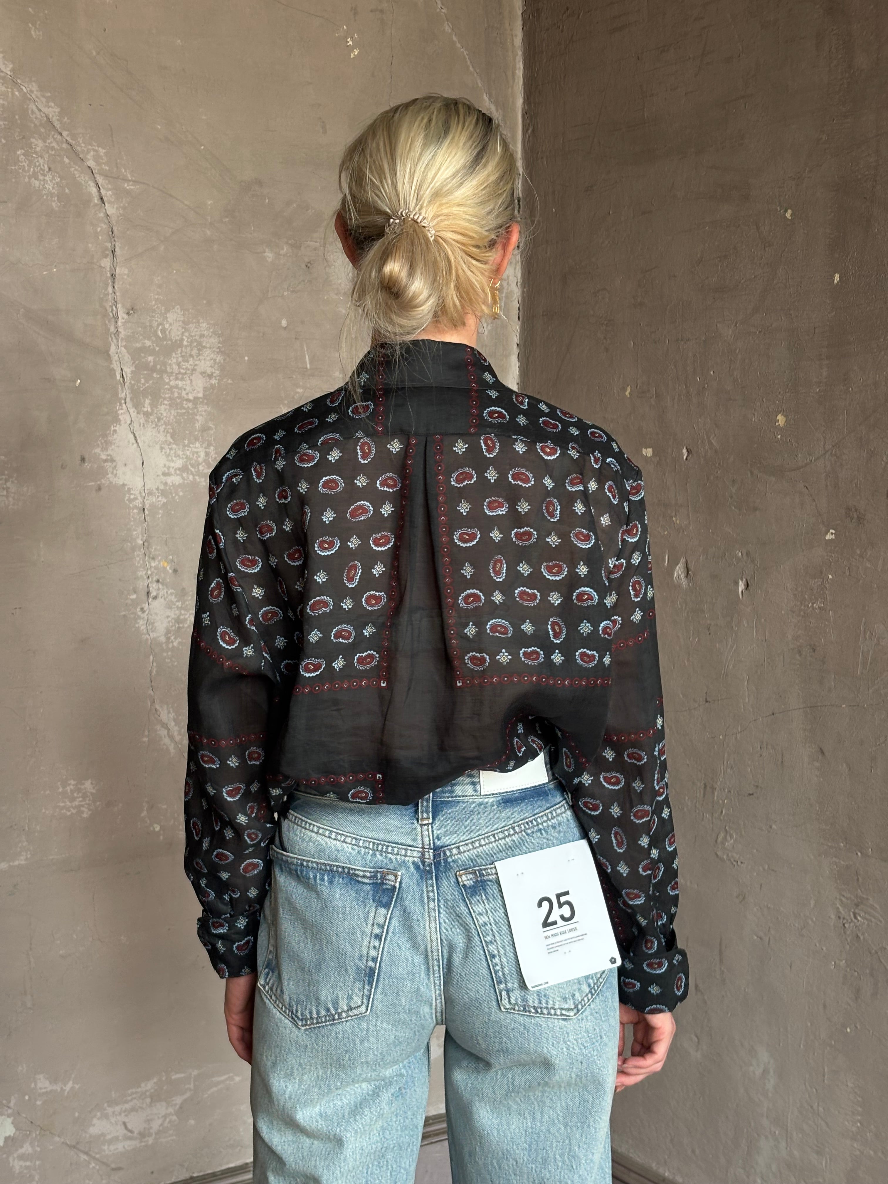 Mature woman wearing designer brand Rachel Comey long sleeve paisley print button down shirt semi-transparent