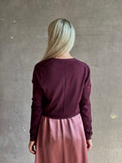 Mature woman wearing Rachel Comey long sleeve burgundy cardigan leightweight plunging v-neck layering