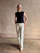 Mature woman wearing Rachel Comey designer Relent sleeveless black cotton knit top with a scalloped edges 