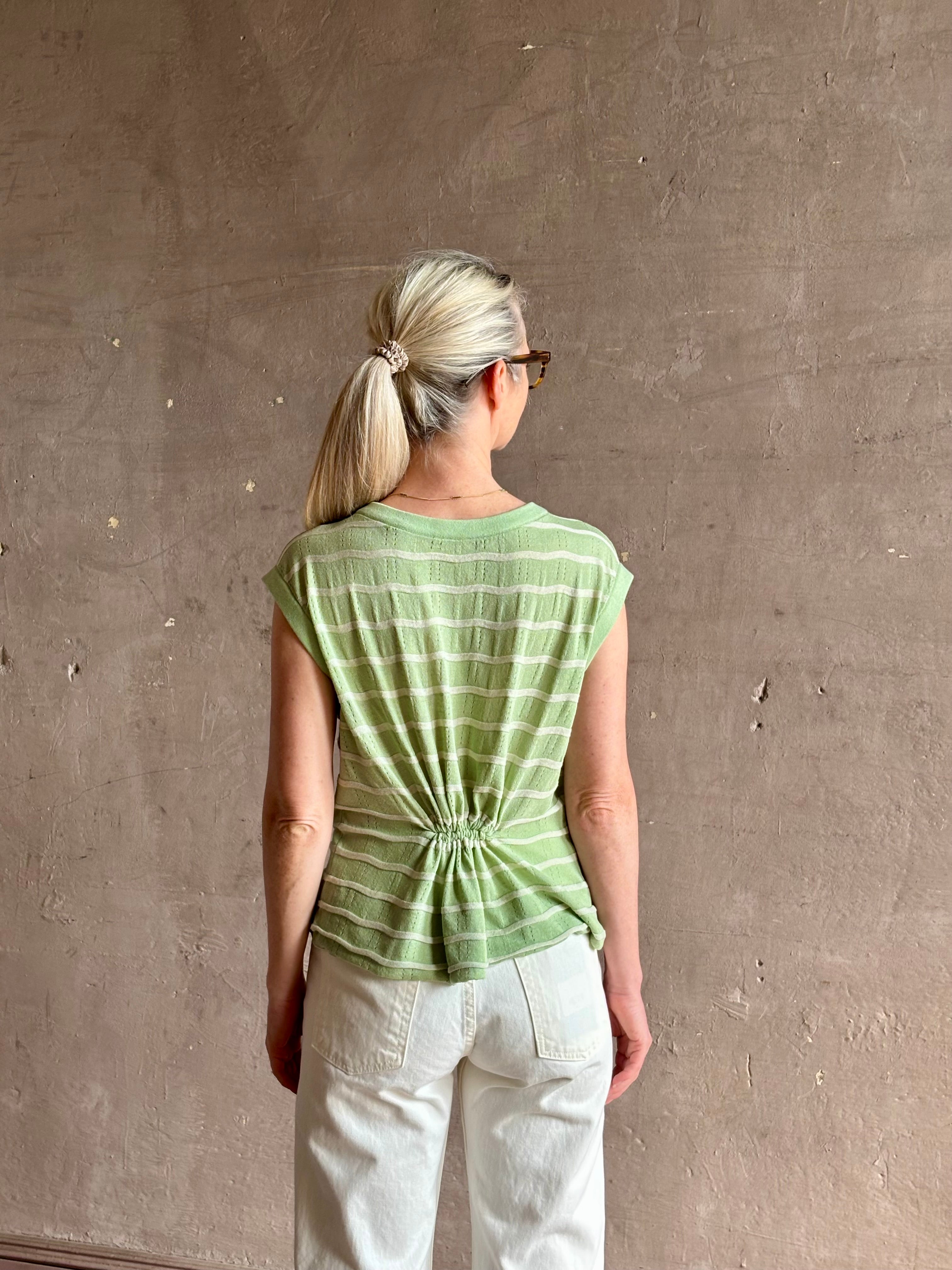 Mature woman wearing light green white horizontally striped Rachel Comey top  gathered twist waist detail reversable