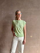 Mature woman wearing light green white horizontally striped Rachel Comey top  gathered twist waist detail reversable