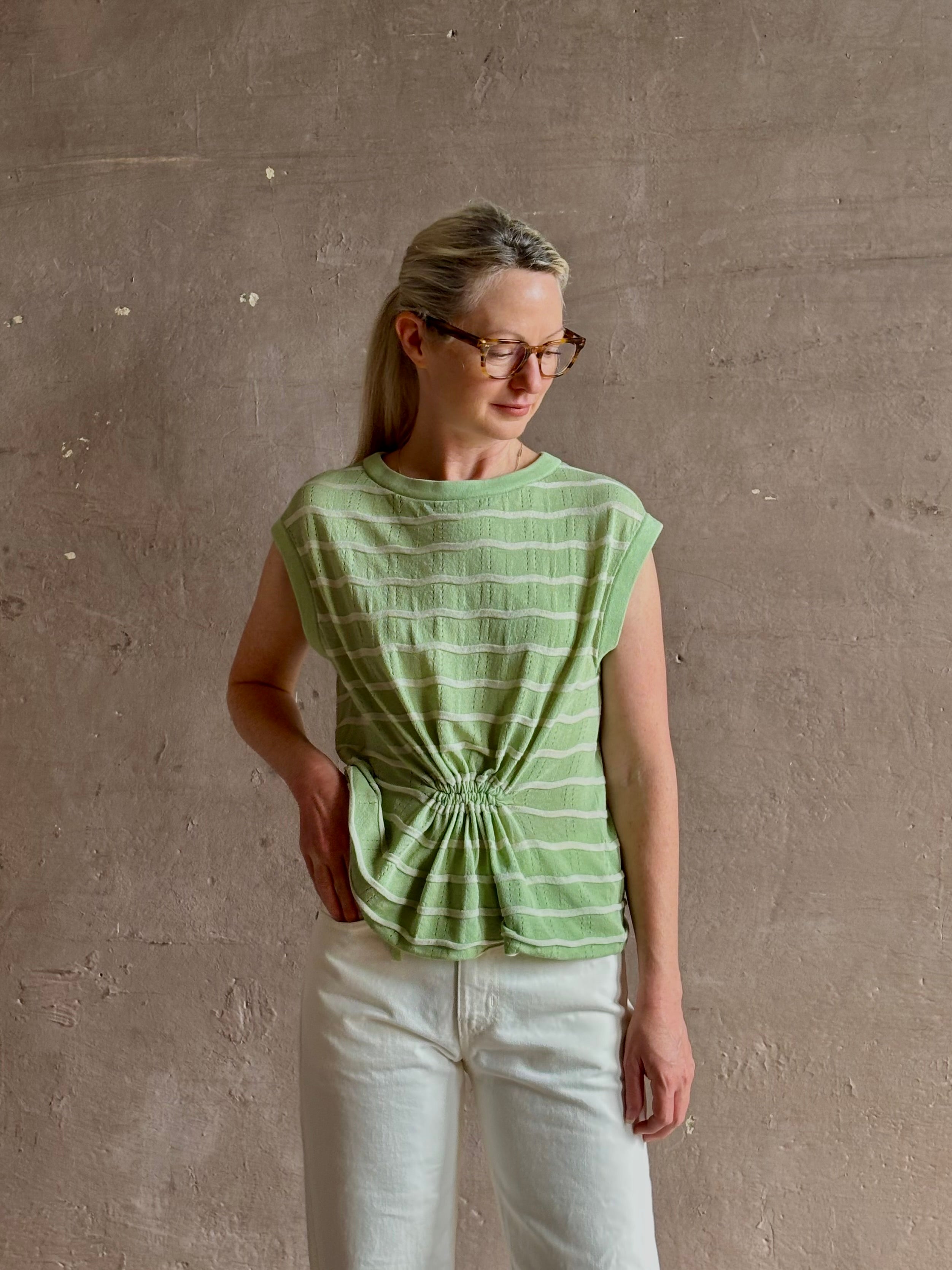 Mature woman wearing light green white horizontally striped Rachel Comey top  gathered twist waist detail reversable