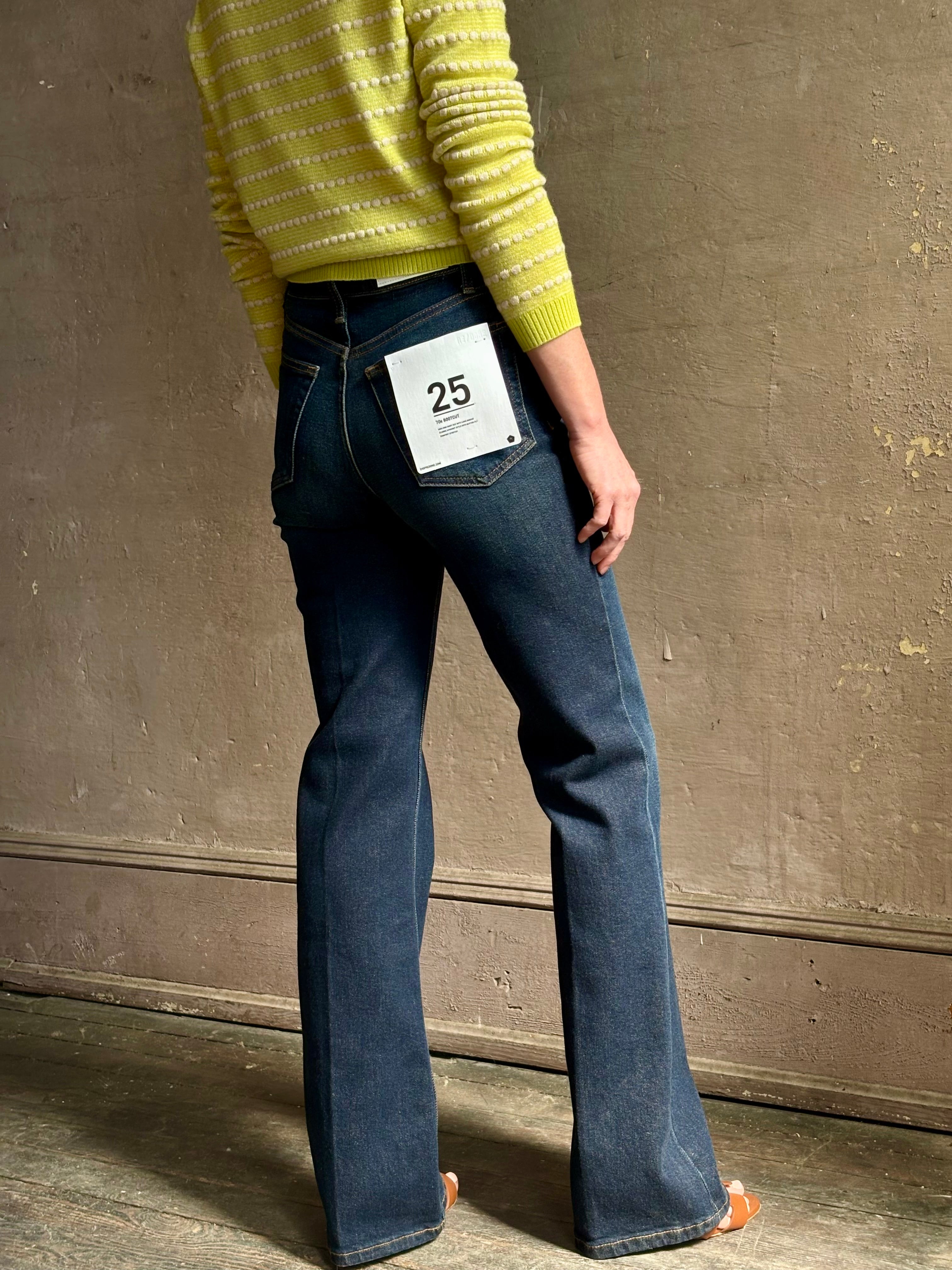 Woman wearing REDONE 70s Bootcut Denim in a dark blue wash with comfort stretch zip closure finished hem and 10.75" rise
