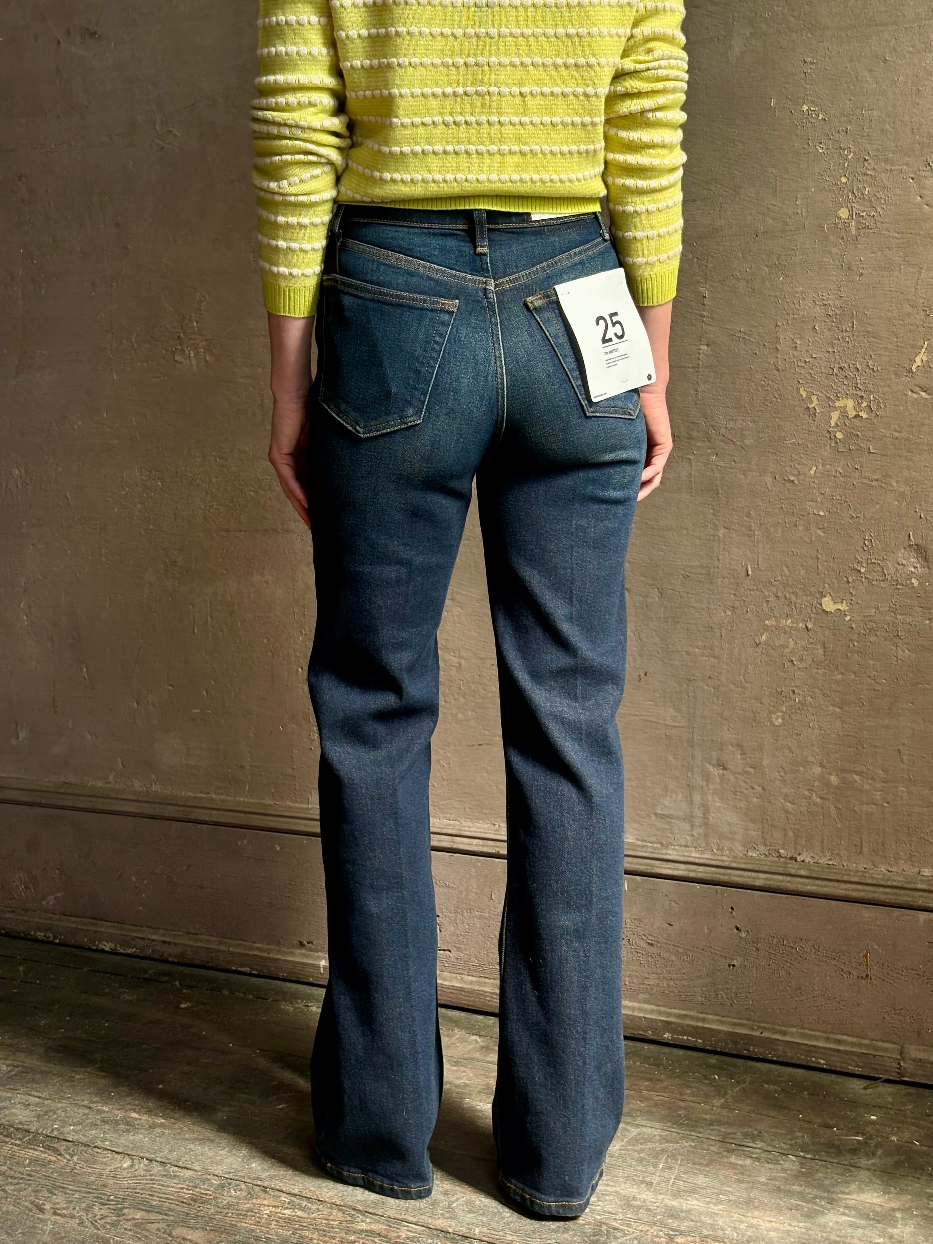 Woman wearing REDONE 70s Bootcut Denim in a dark blue wash with comfort stretch zip closure finished hem and 10.75" rise