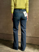 Woman wearing REDONE 70s Bootcut Denim in a dark blue wash with comfort stretch zip closure finished hem and 10.75" rise