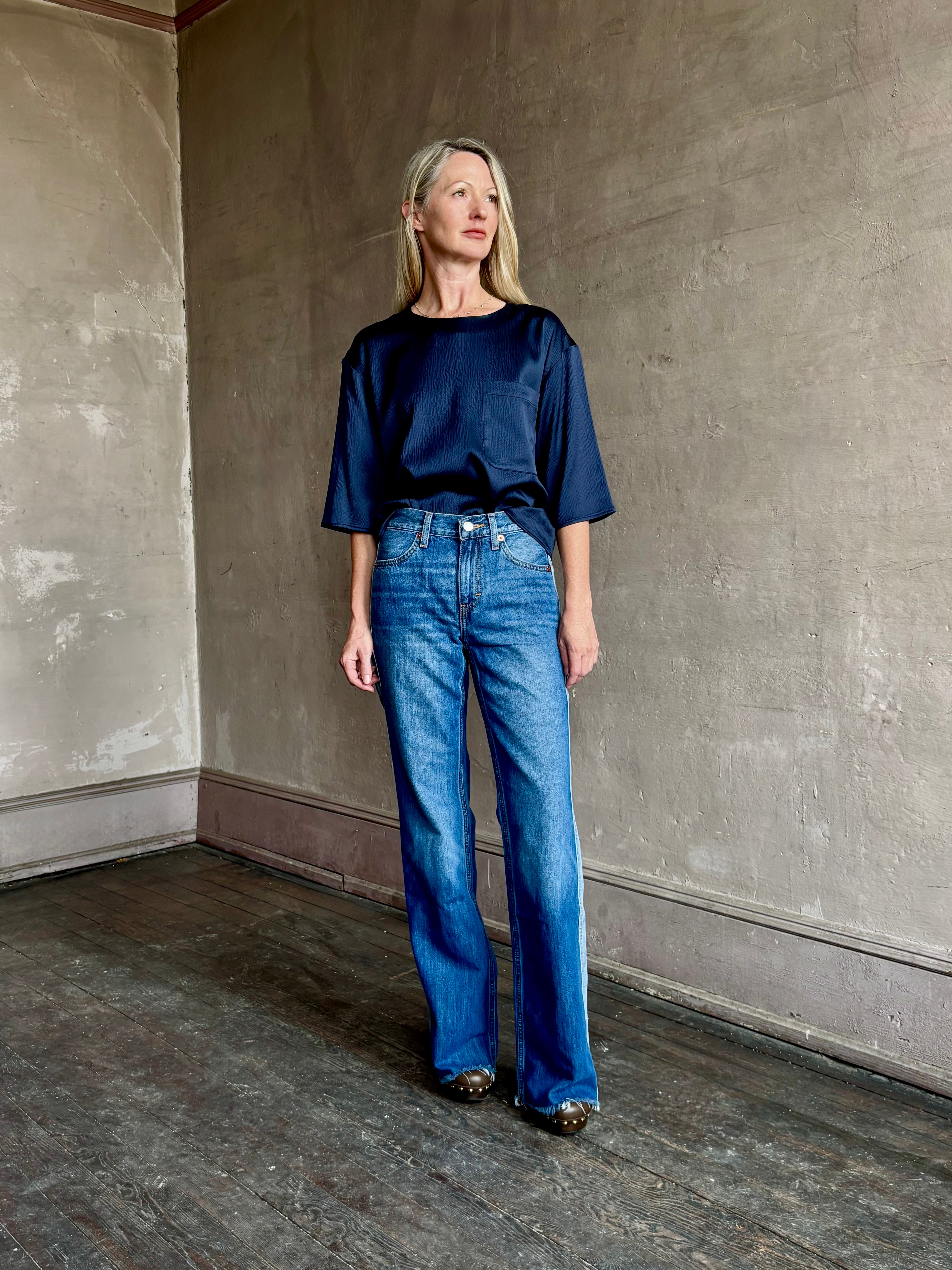 Image of mature woman wearing mid-rise jean ReDone track Californian denim with light blue stripe down side in Viper blue wash