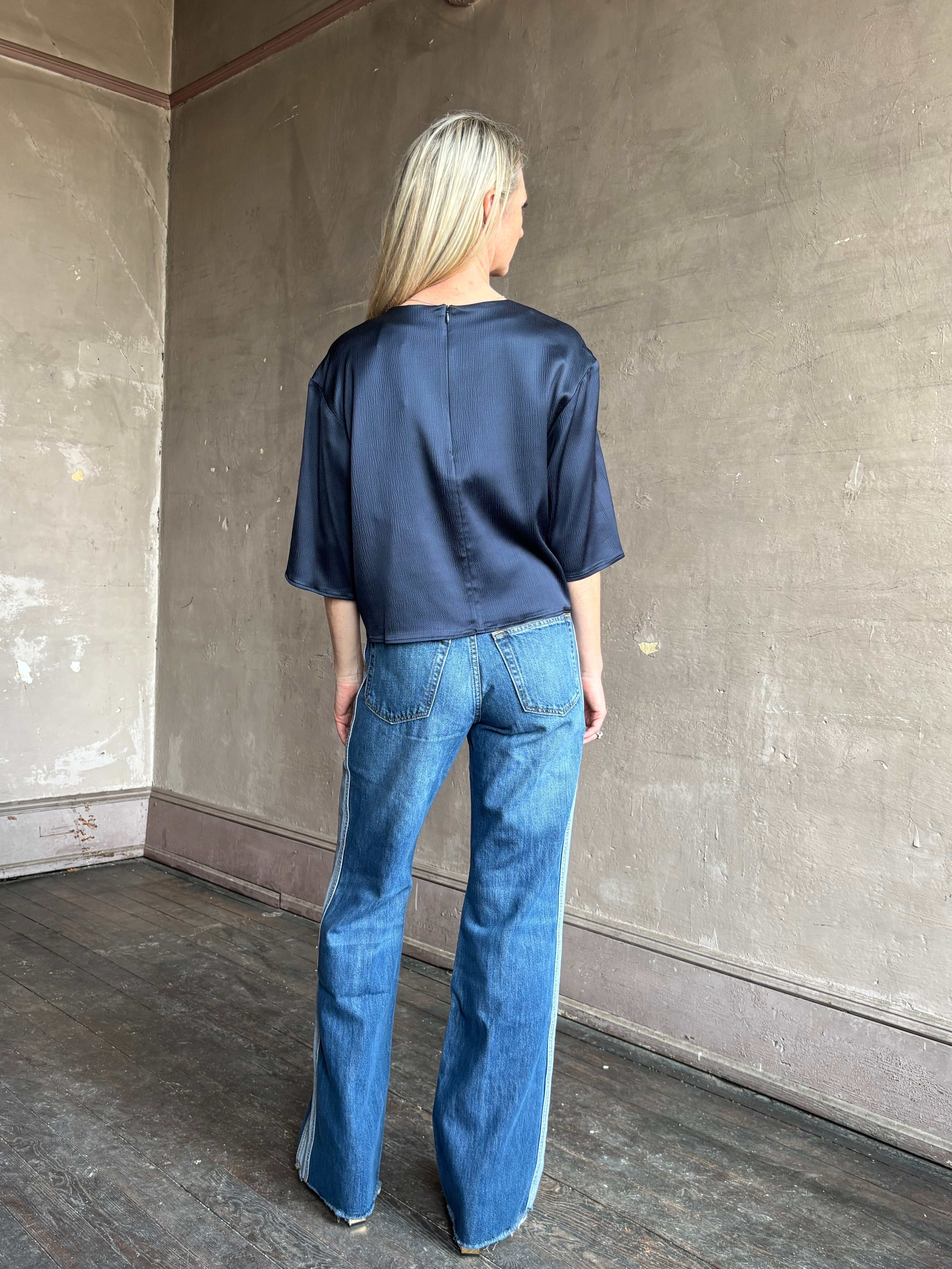 Image of mature woman wearing mid-rise jean ReDone track Californian denim with light blue stripe down side in Viper blue wash