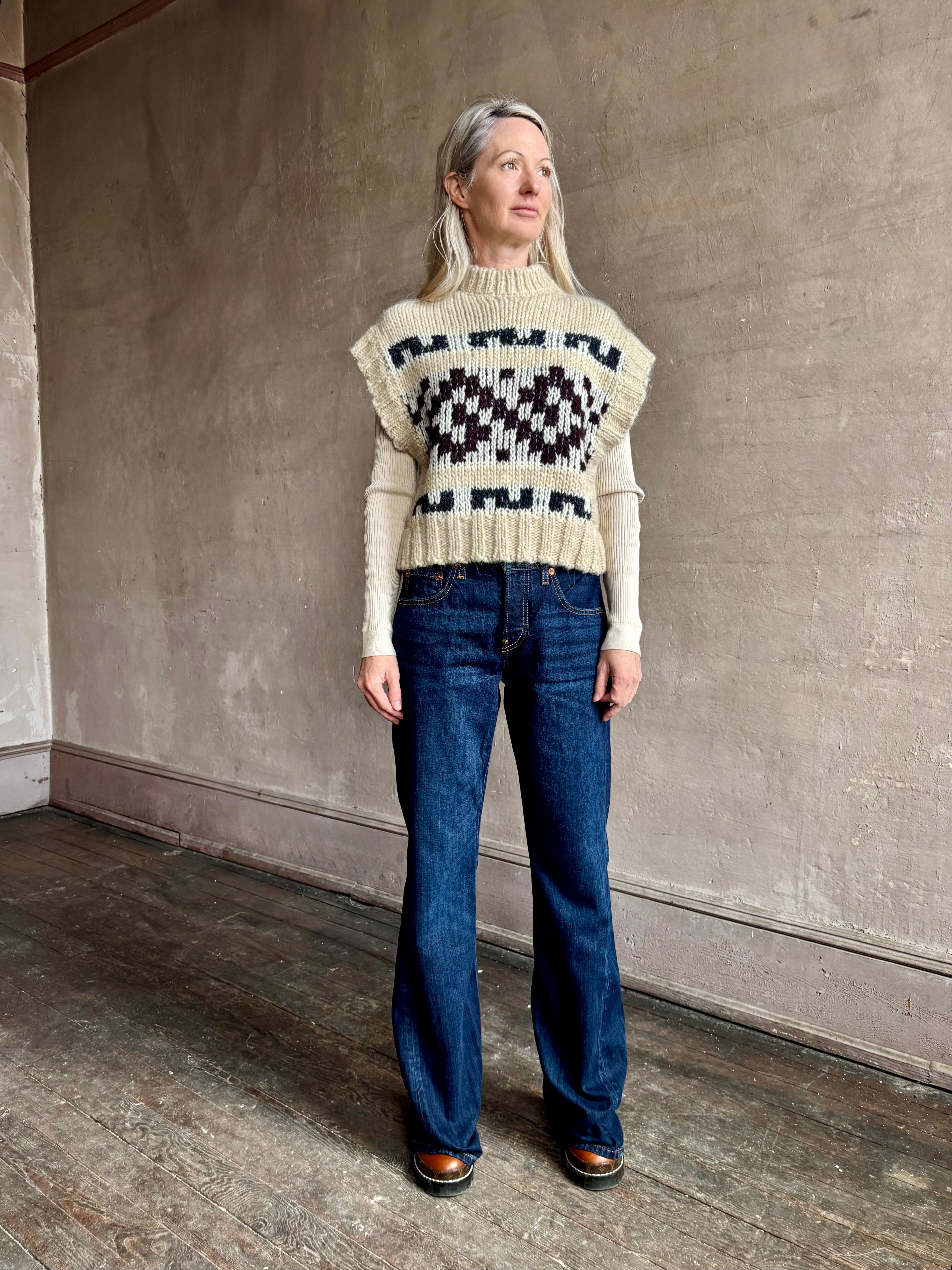 Woman wearing REDONE Twisted Mid Rise Bootcut Denim in a clean dark blue wash with a 9.5" rise and finished hem