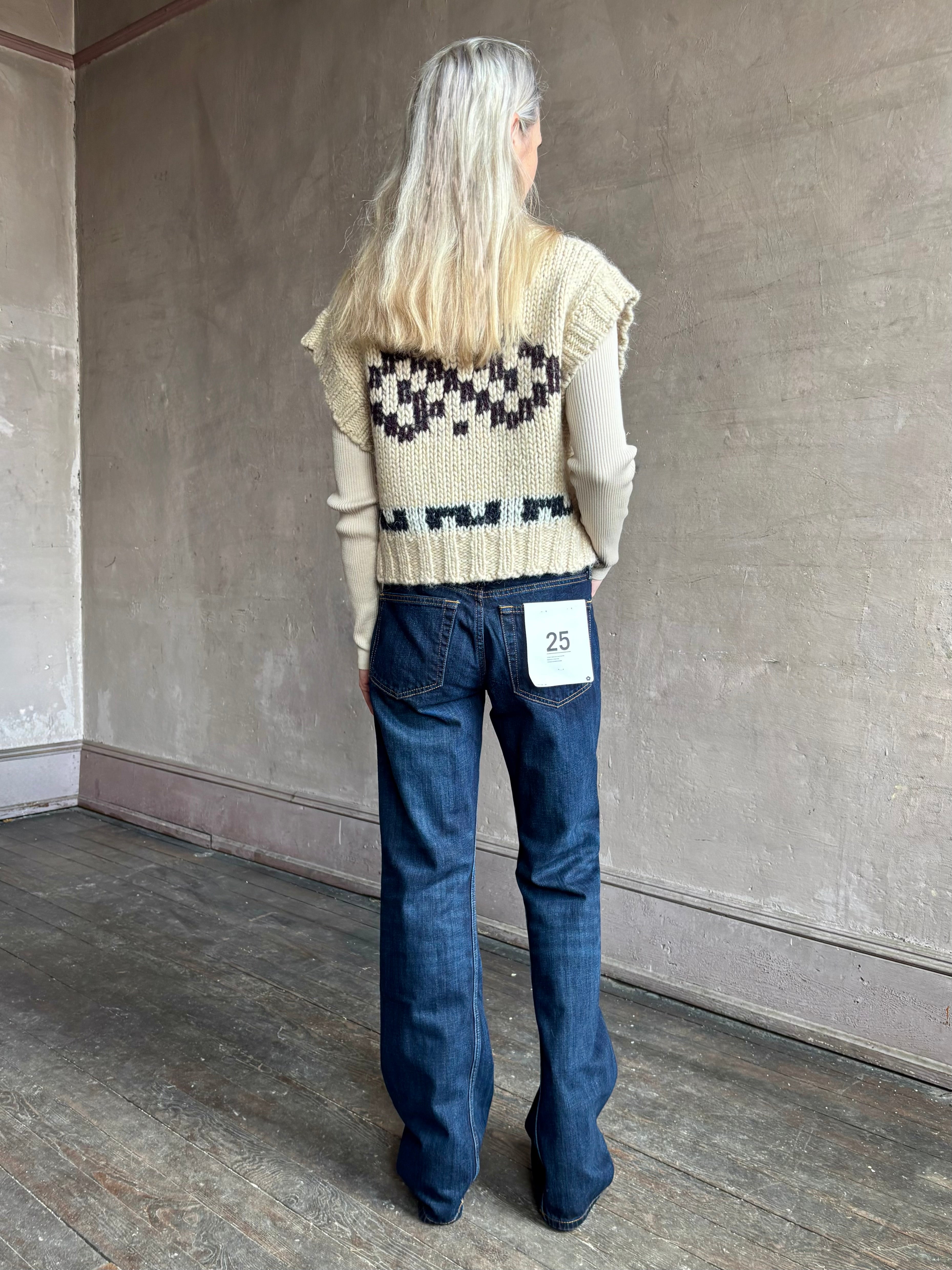 Woman wearing REDONE Twisted Mid Rise Bootcut Denim in a clean dark blue wash with a 9.5" rise and finished hem