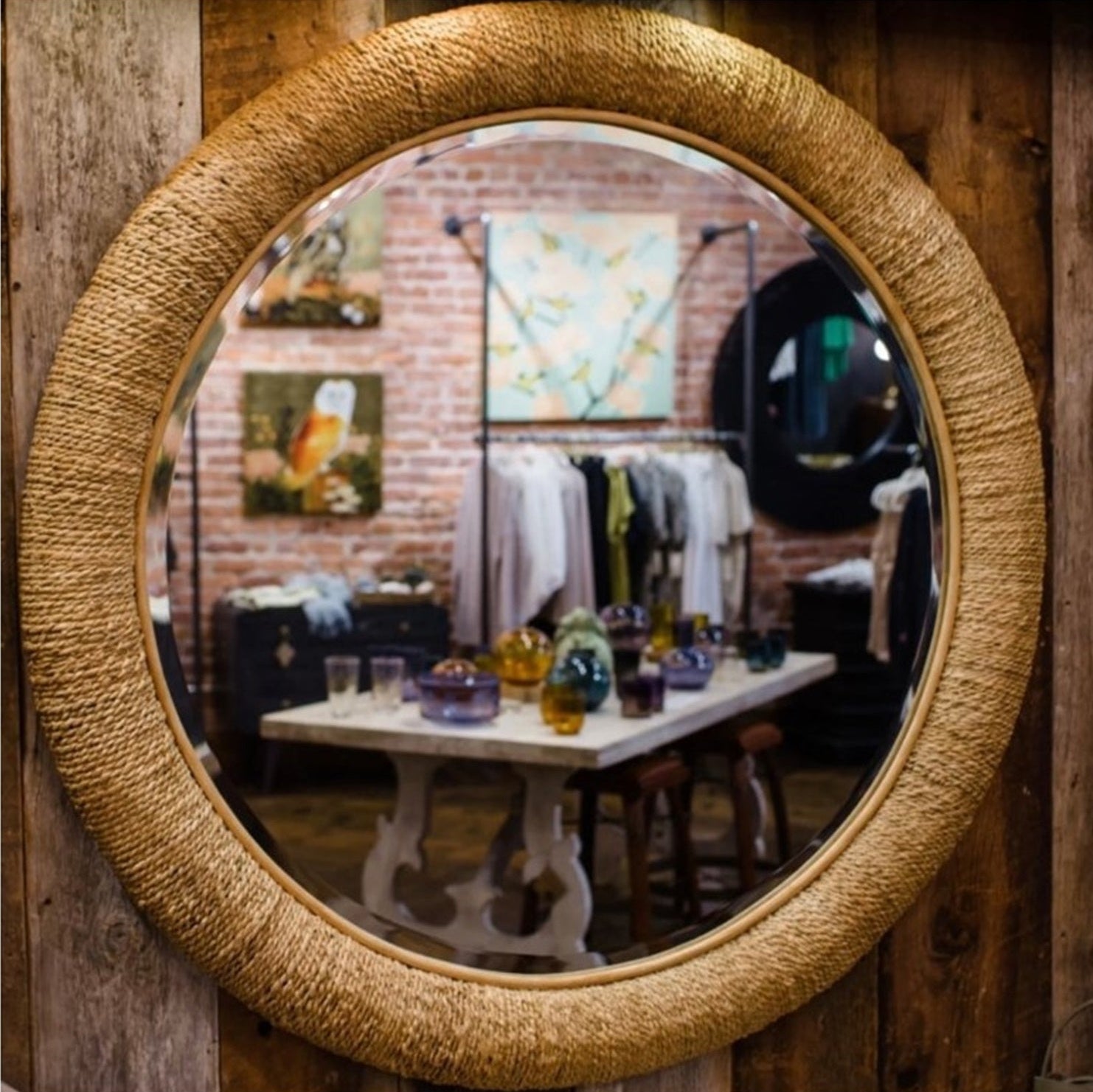 Large round beveled glass mirror with a textured natural raffia frame for a refined natural finishing touch to home