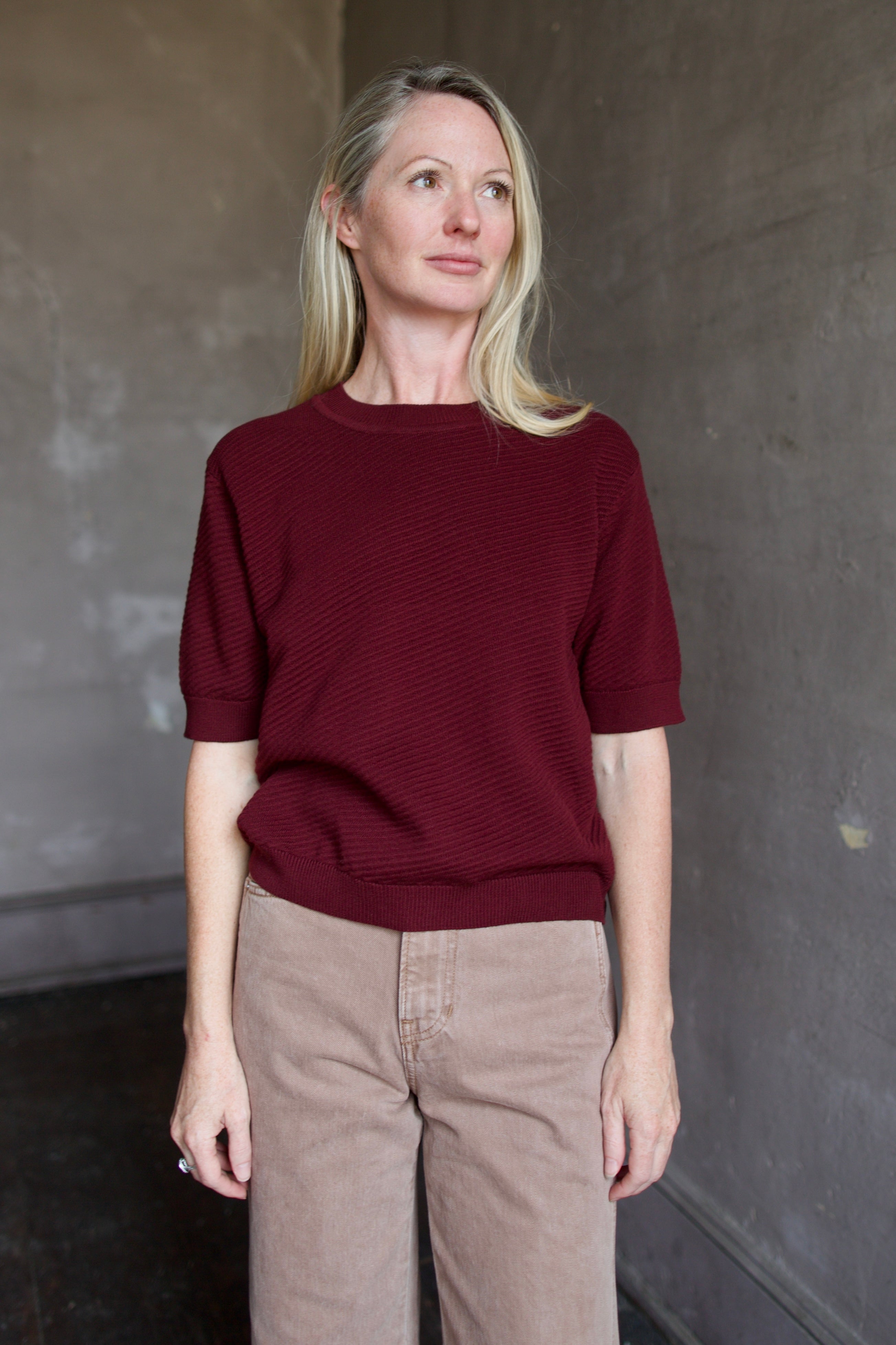 Model wearing a burgundy baby alpaca sweater by New York designer Rachel Comey