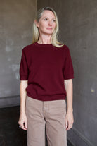 Model wearing a burgundy baby alpaca sweater by New York designer Rachel Comey