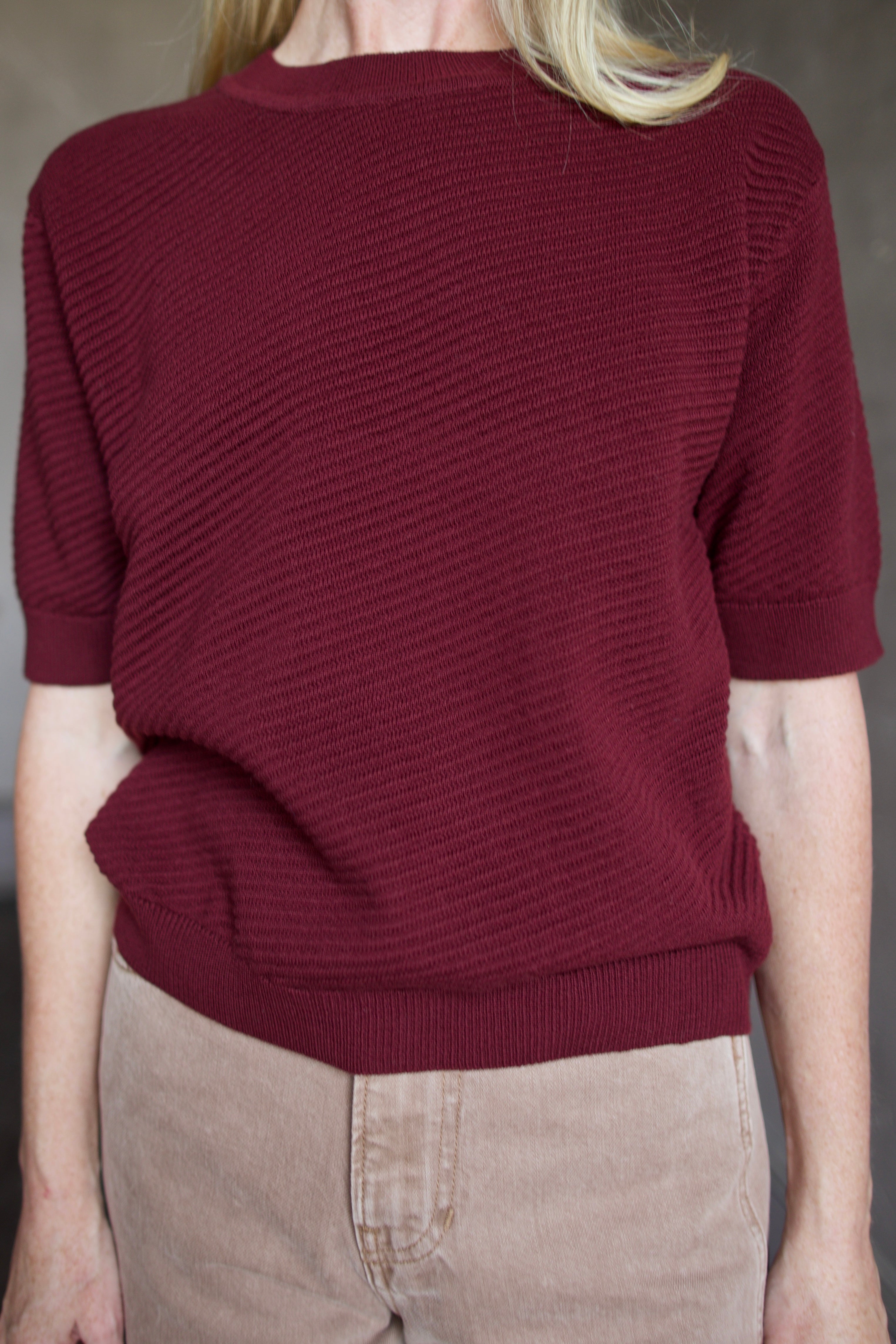 Model wearing a burgundy baby alpaca sweater by New York designer Rachel Comey
