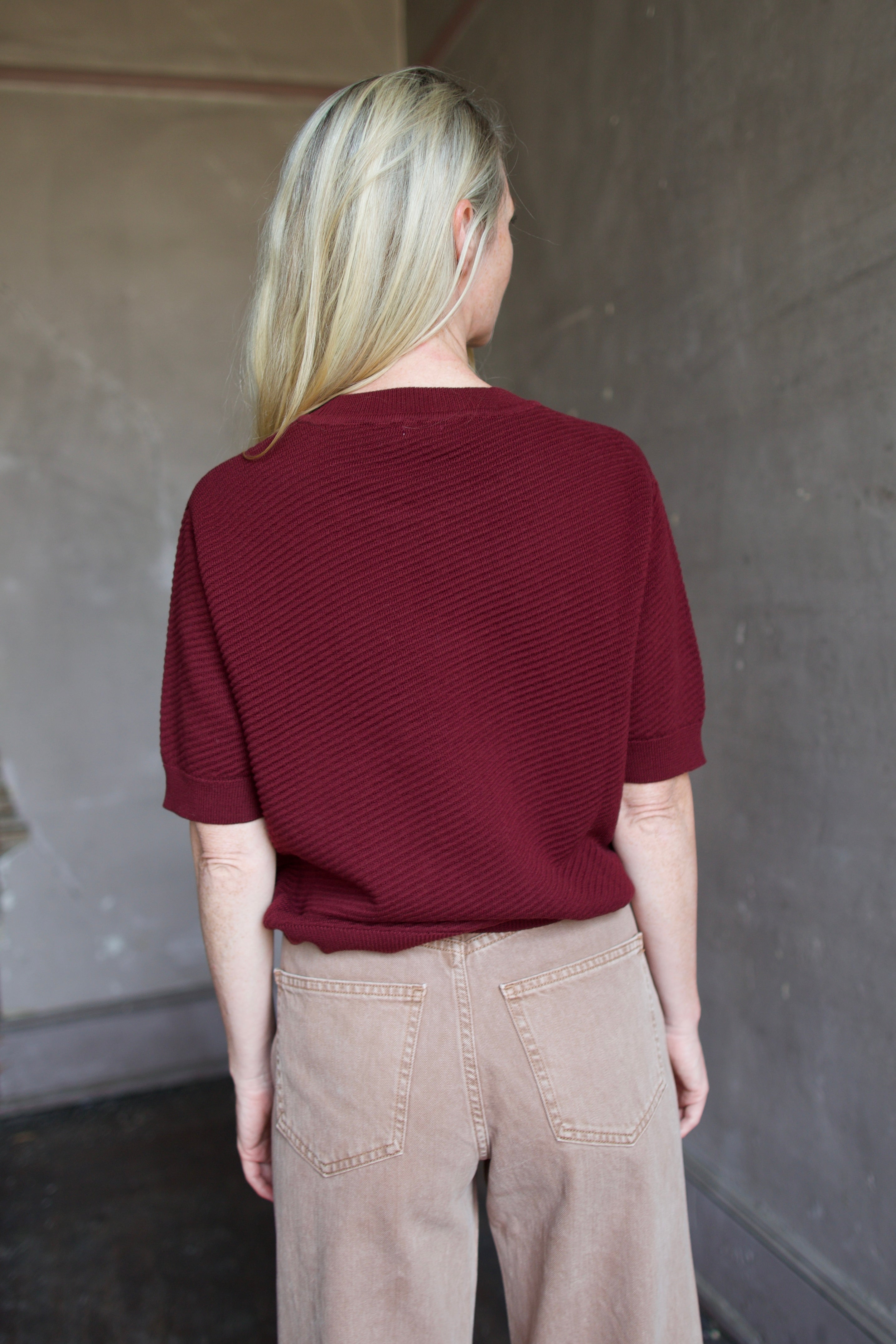 Model wearing a burgundy baby alpaca sweater by New York designer Rachel Comey