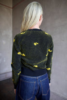 Model wearing a black Rachel Comey sweater with yellow floral patterns 