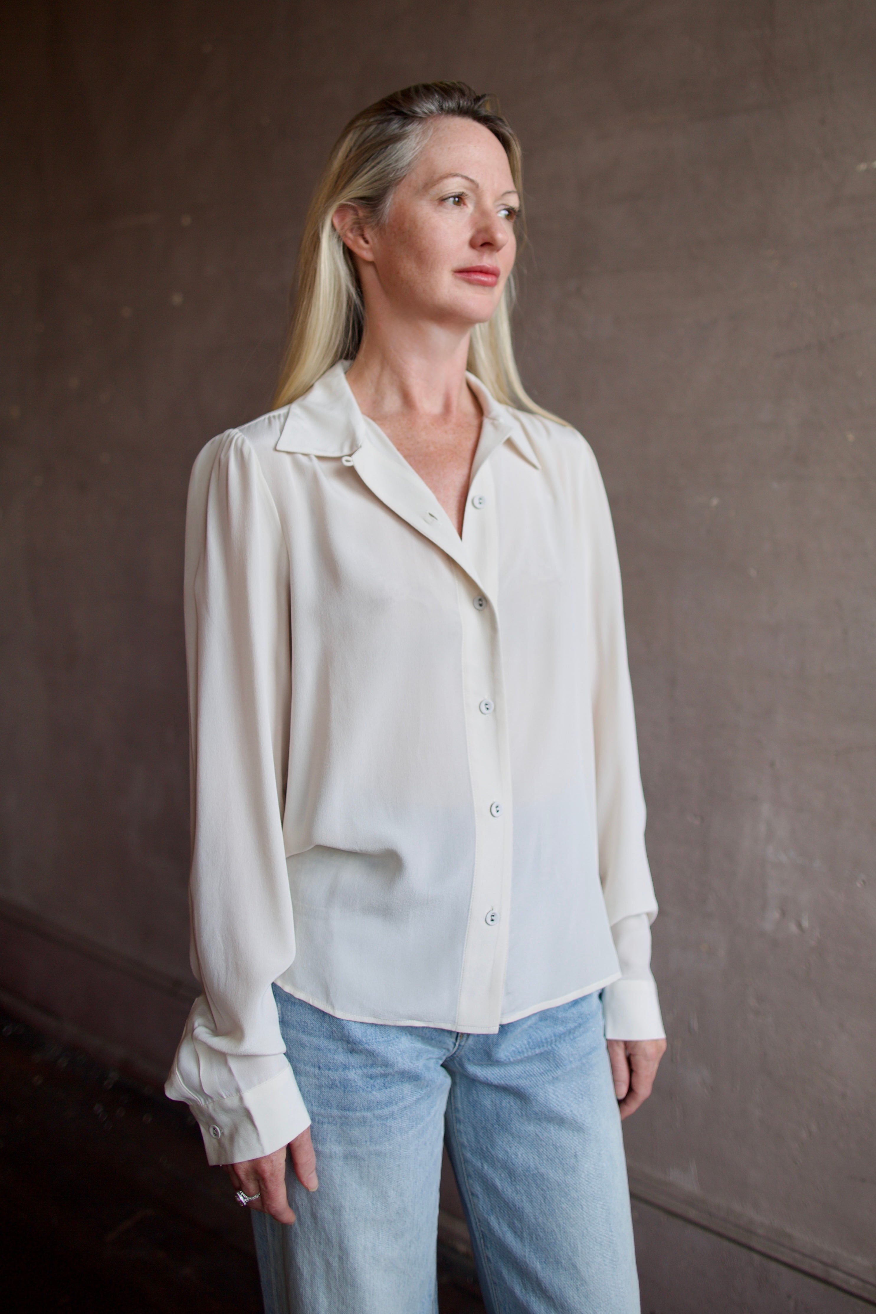Model wearing a beige silk button down timeless blouse by Rachel Comey