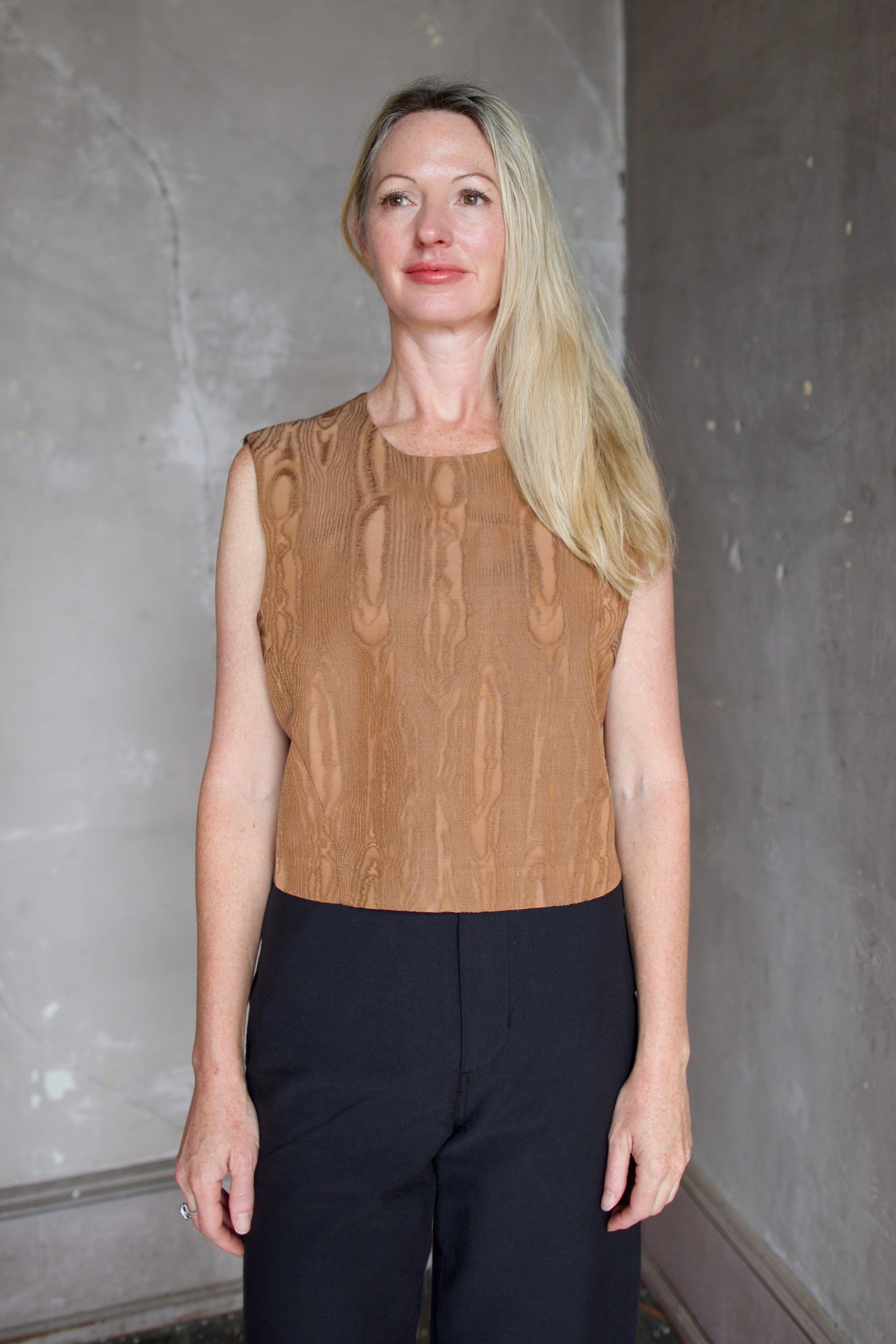 Model wearing a brown faux boise patterned top by designer Rachel Comey layered over a button down