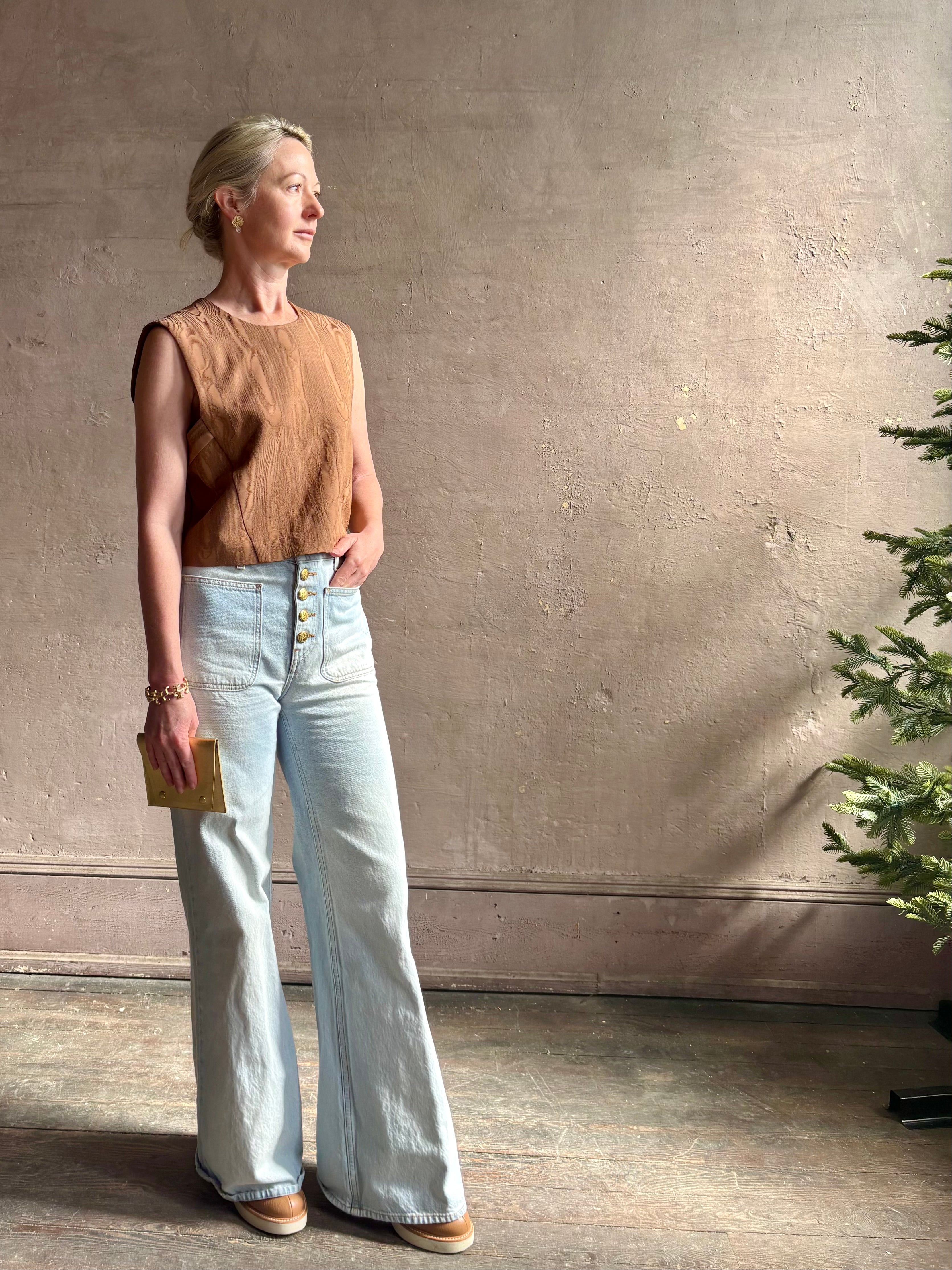 Mature woman wearing a brown faux boise patterned sleeveless viscose top by designer Rachel Comey with a crew neckline and button back closure