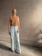 Mature woman wearing a brown faux boise patterned sleeveless viscose top by designer Rachel Comey with a crew neckline and button back closure
