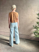 Mature woman wearing a brown faux boise patterned sleeveless viscose top by designer Rachel Comey with a crew neckline and button back closure