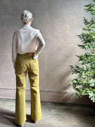 Mature woman wearing Premium Baby Alpaca Mulberry Silk Calma shirt by Rachel Comey with button front, long sleeves and collar rendered in cream