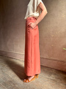 Mature woman wearing premium wool silk  women's designer Rachel Comey Cosa maxi Skirt with tailored waistband, belt loops and back vent rendered in a vibrant warm pink hue