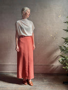 Mature woman wearing premium wool silk  women's designer Rachel Comey Cosa maxi Skirt with tailored waistband, belt loops and back vent rendered in a vibrant warm pink hue
