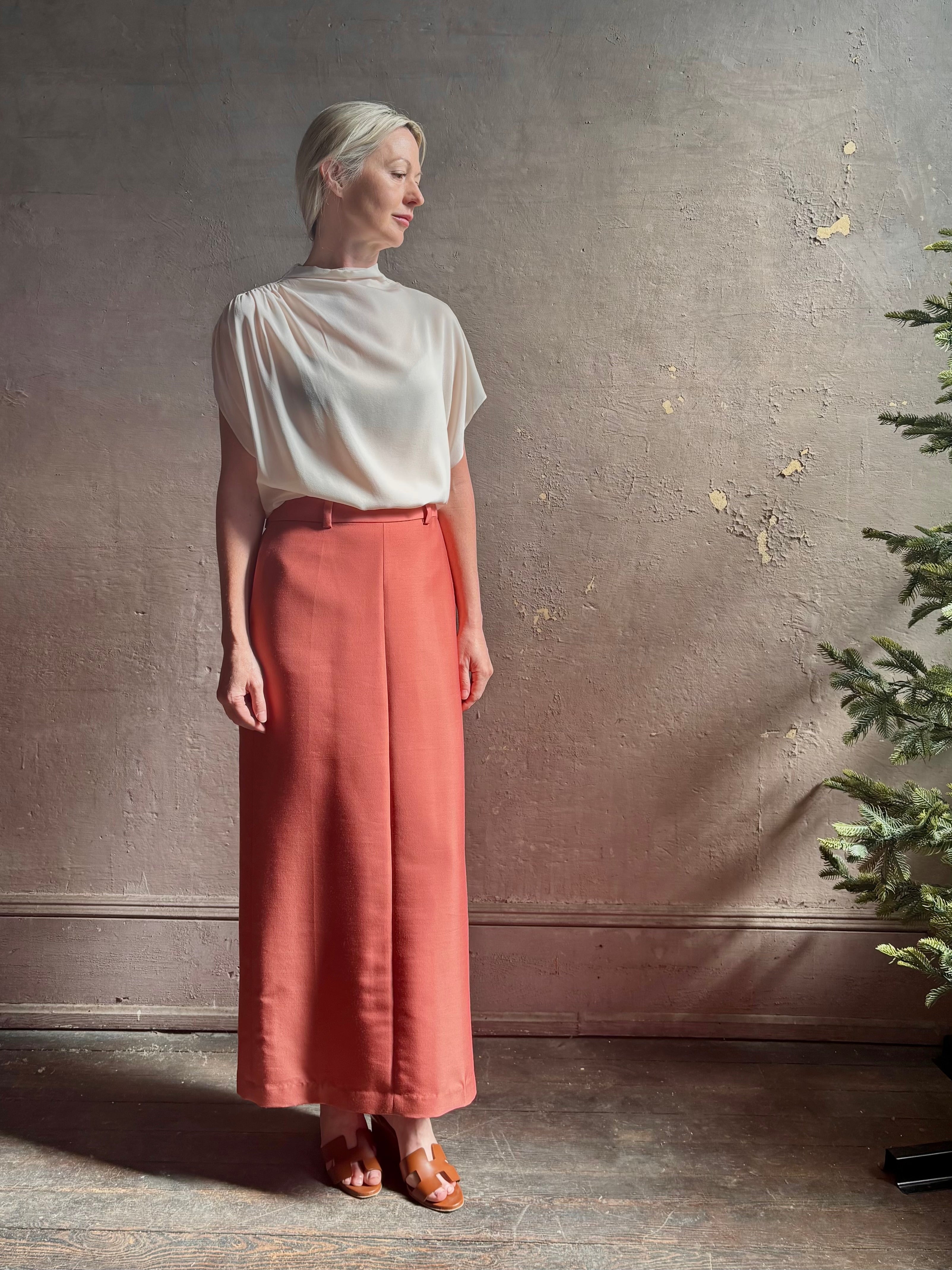 Mature woman wearing premium wool silk  women's designer Rachel Comey Cosa maxi Skirt with tailored waistband, belt loops and back vent rendered in a vibrant warm pink hue