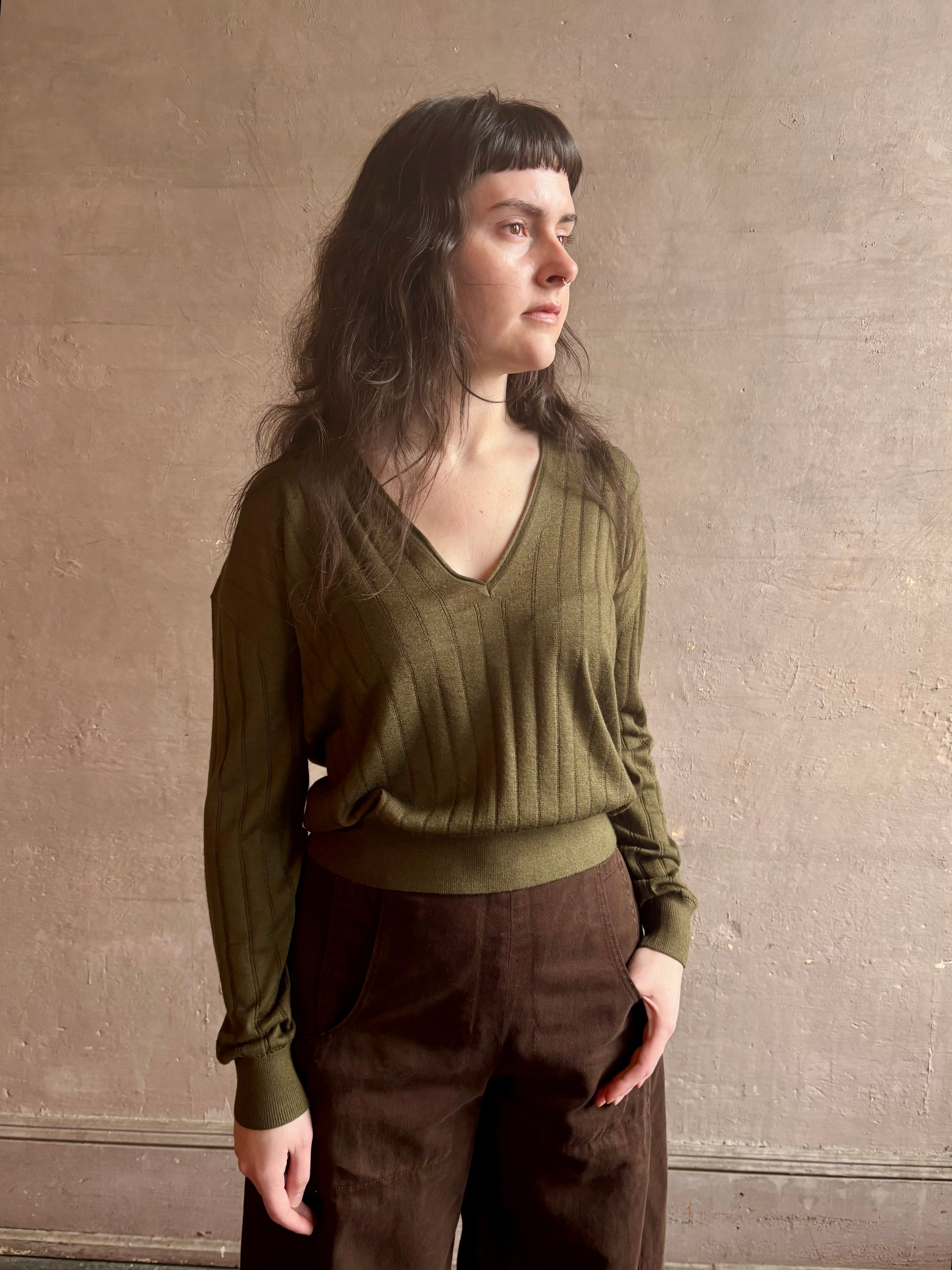 Image of woman wearing luxury Cashmere Silk Marion V-Neck designer Sweater by Rachel Comey in olive green with long sleeves and linear weave