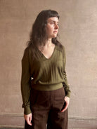 Image of woman wearing luxury Cashmere Silk Marion V-Neck designer Sweater by Rachel Comey in olive green with long sleeves and linear weave