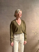 Mature woman wearing luxury Cashmere Silk Marion V-Neck designer Sweater by Rachel Comey in olive green with long sleeves and linear weave