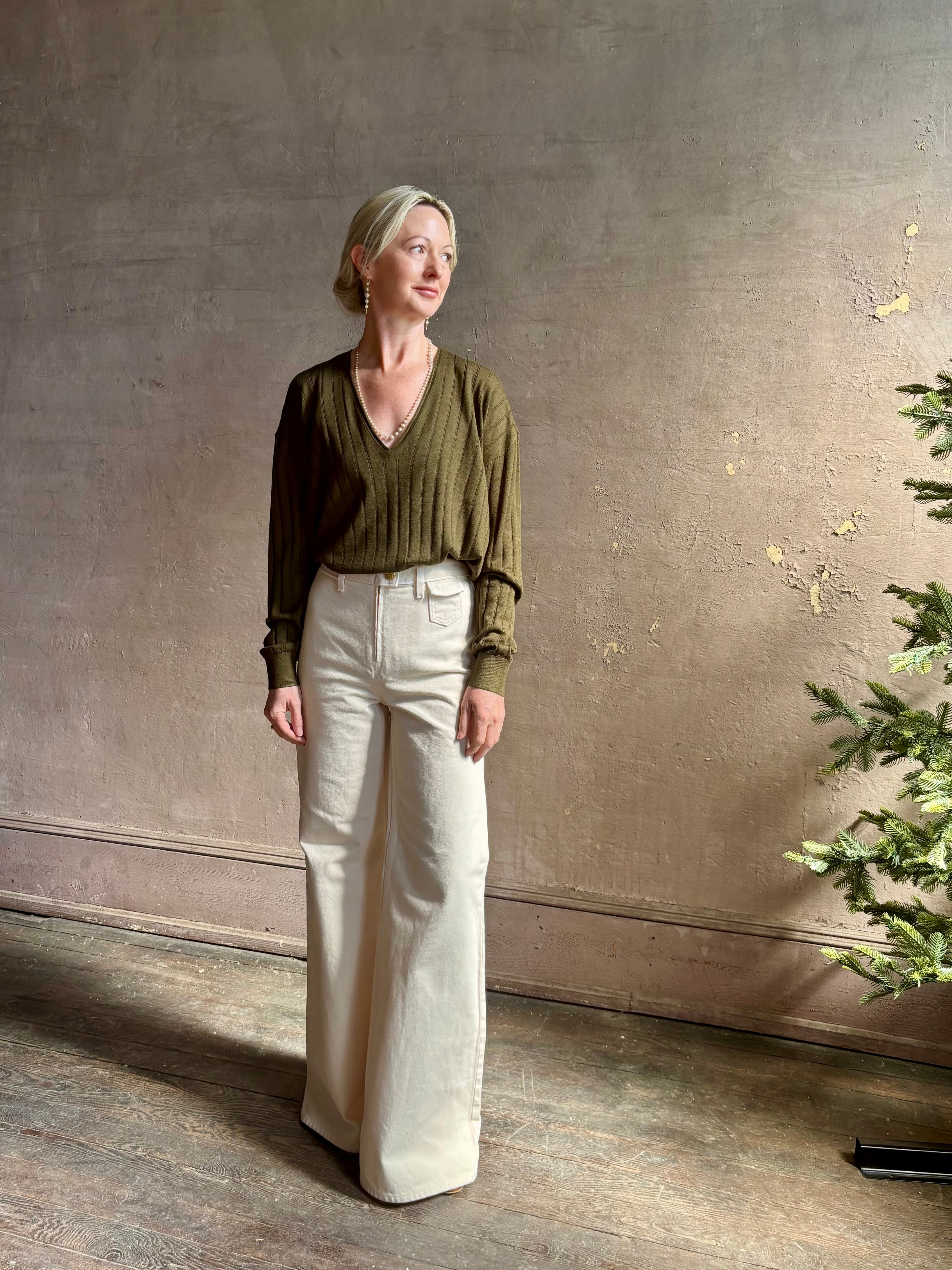 Mature woman wearing luxury Cashmere Silk Marion V-Neck designer Sweater by Rachel Comey in olive green with long sleeves and linear weave
