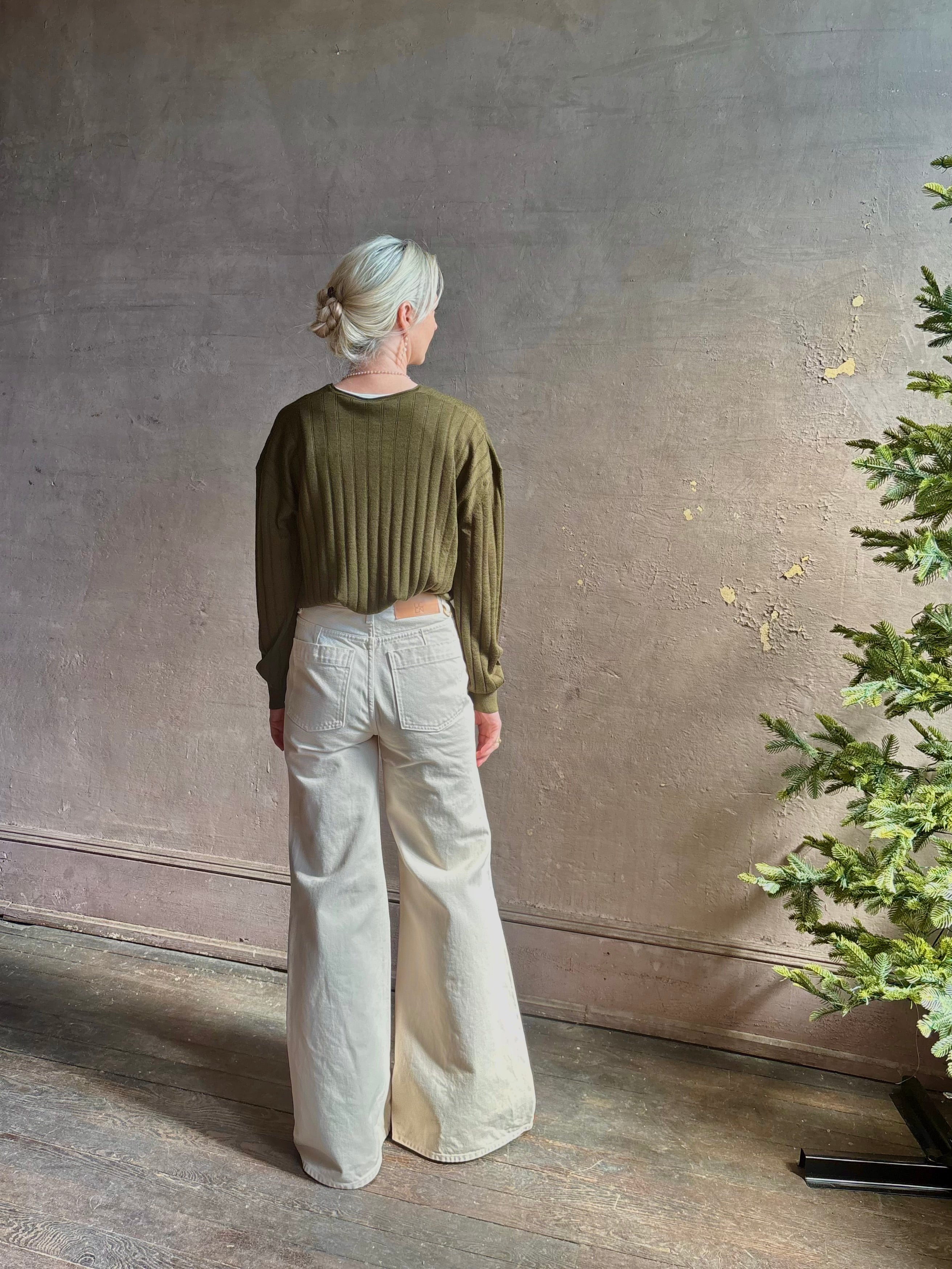 Mature woman wearing luxury Cashmere Silk Marion V-Neck designer Sweater by Rachel Comey in olive green with long sleeves and linear weave