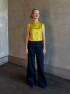 Mature woman wearing Rachel Comey Primula Pique Knit Top in Mustard yellow waterfall front tone-on-tone jacquard floral made in the USA