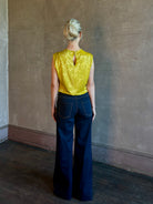 Mature woman wearing Rachel Comey Primula Pique Knit Top in Mustard yellow waterfall front tone-on-tone jacquard floral made in the USA