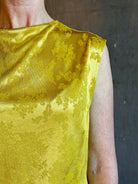 Mature woman wearing Rachel Comey Primula Pique Knit Top in Mustard yellow waterfall front tone-on-tone jacquard floral made in the USA