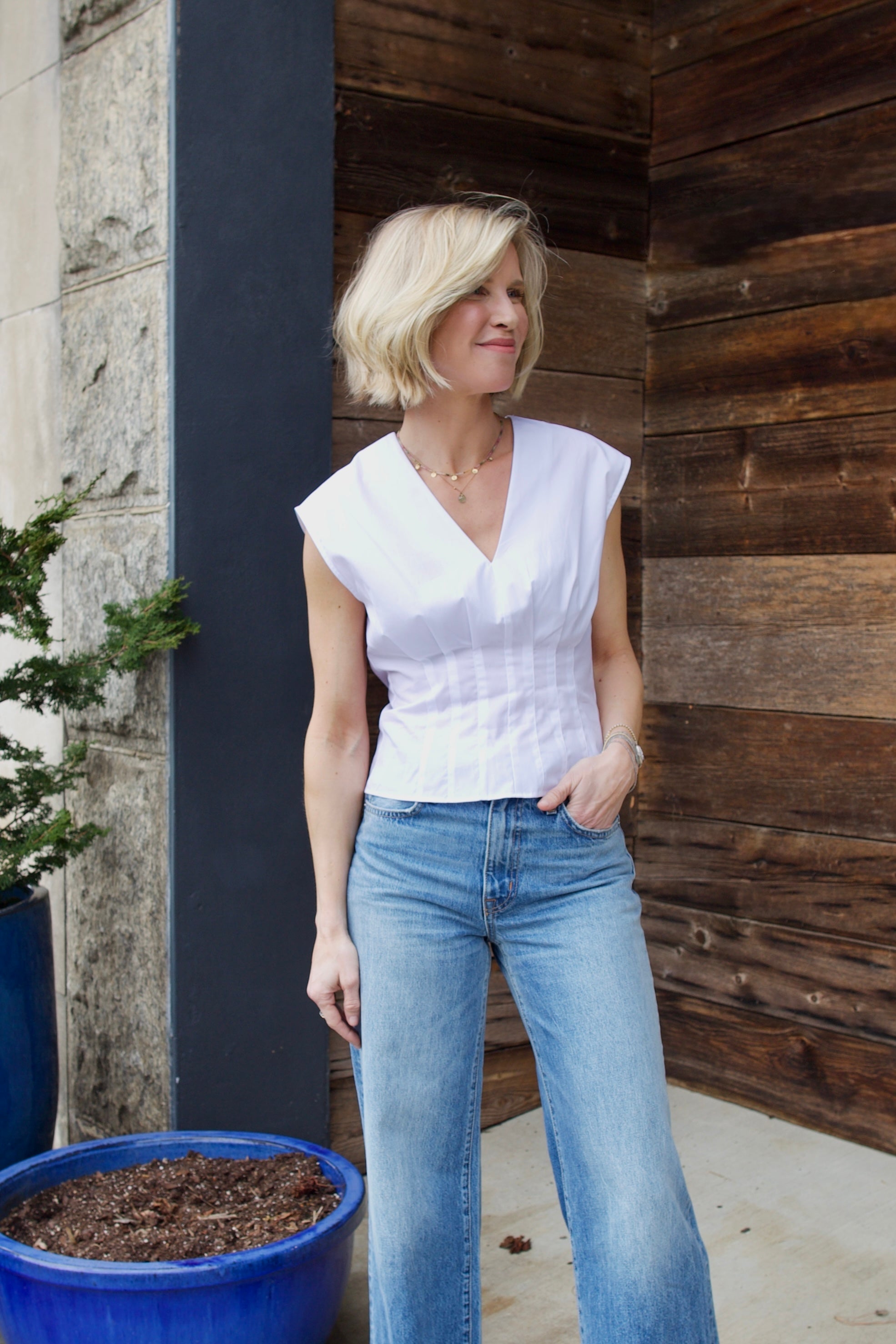 Woman wearing the Rag and Bone Ines luxury women's cotton  poplin top featuring deep V neckline with seam detailing to an elevated basic