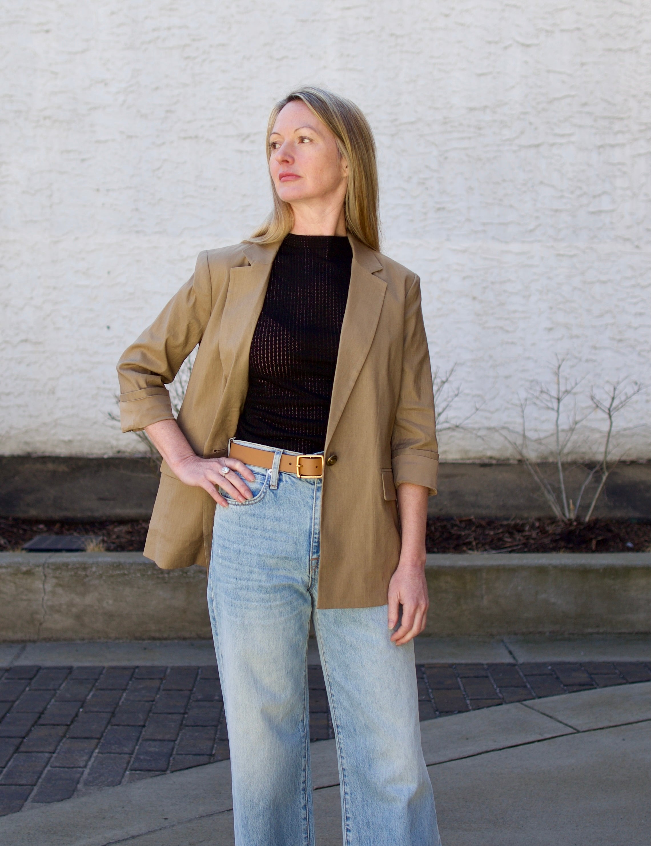 Woman wearing the Rag and Bone Molly Mock Neck black Top in semi-sheer knit construction and expertly designed minimalist silhouette