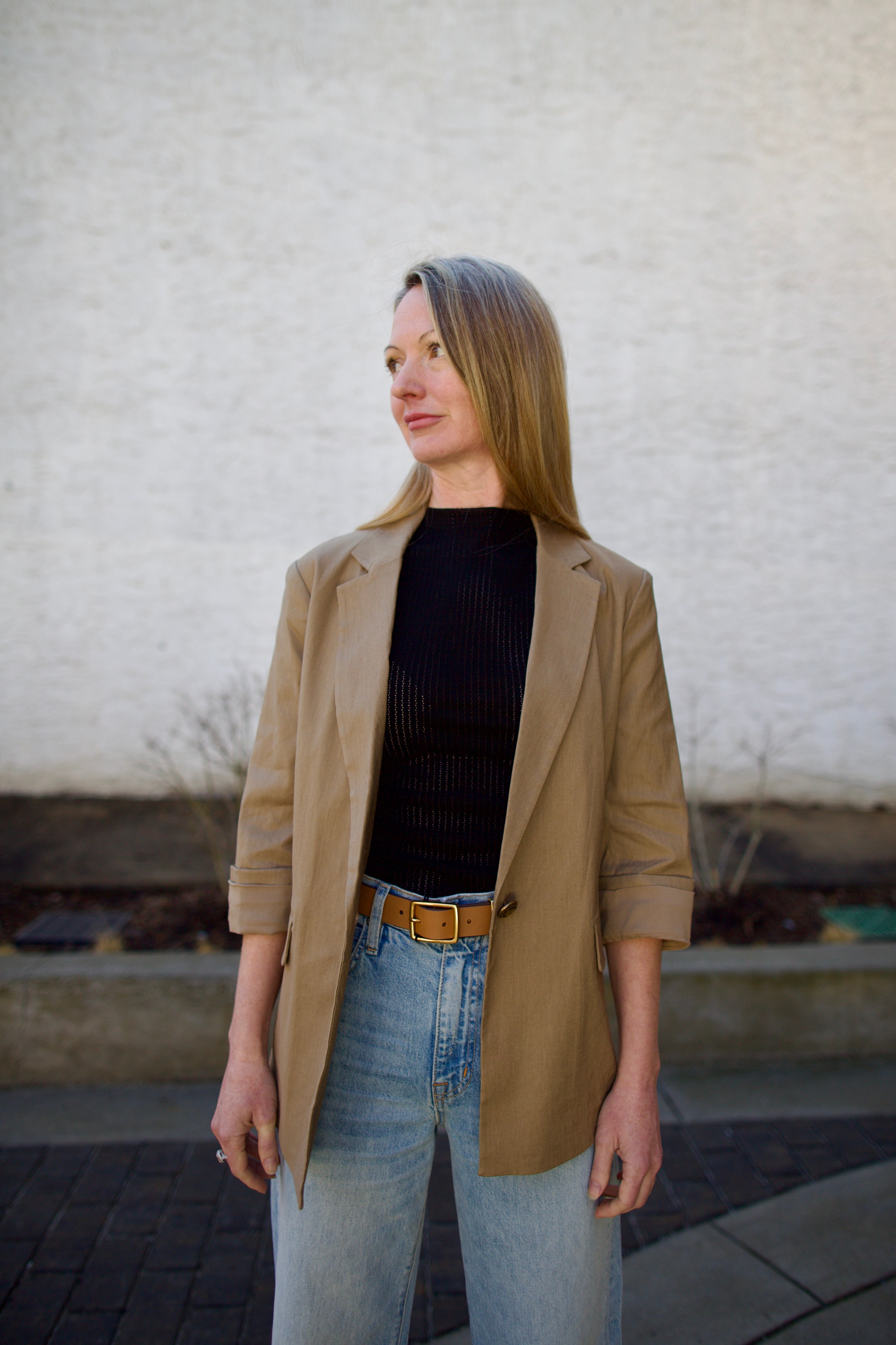 Woman wearing the Rag and Bone Molly Mock Neck black Top in semi-sheer knit construction and expertly designed minimalist silhouette