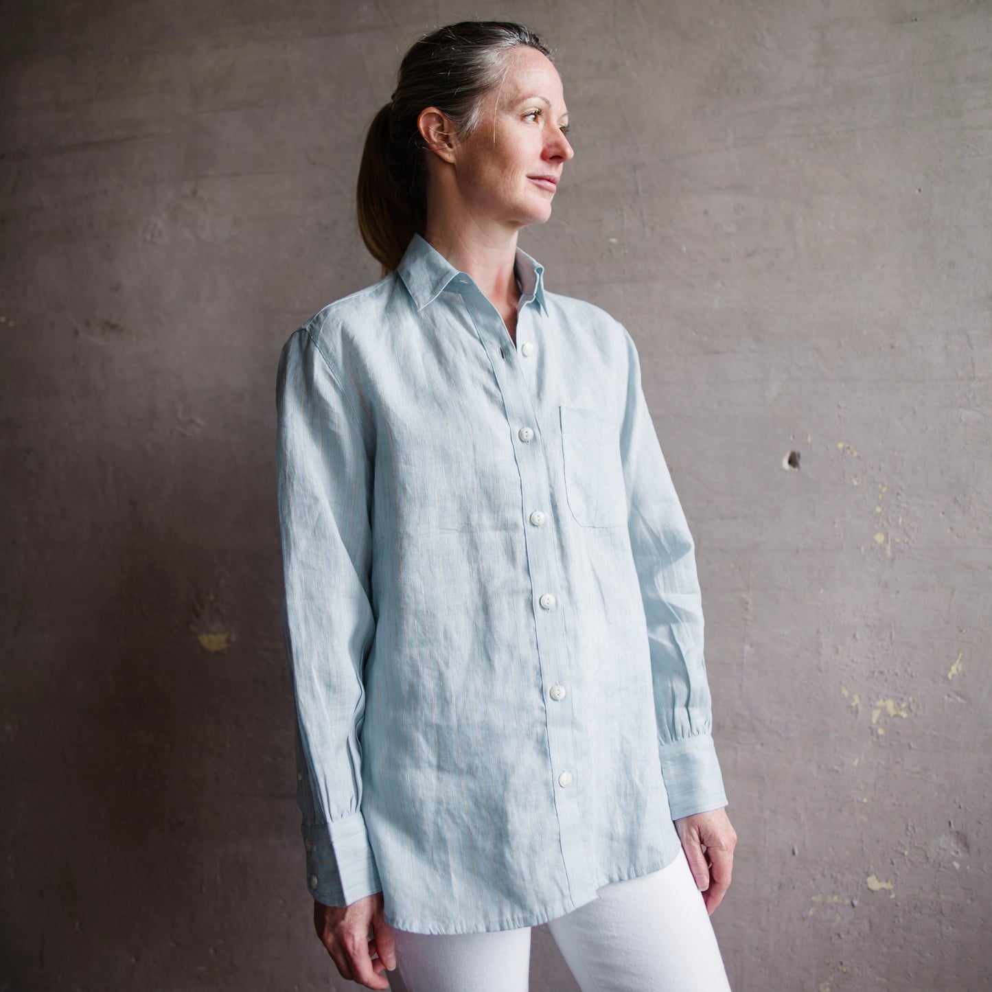 The Maxine Button Down Shirt from Rag & Bone in striped linen and featuring; horn buttons, a box pleat at the center back, and a high-low hem.