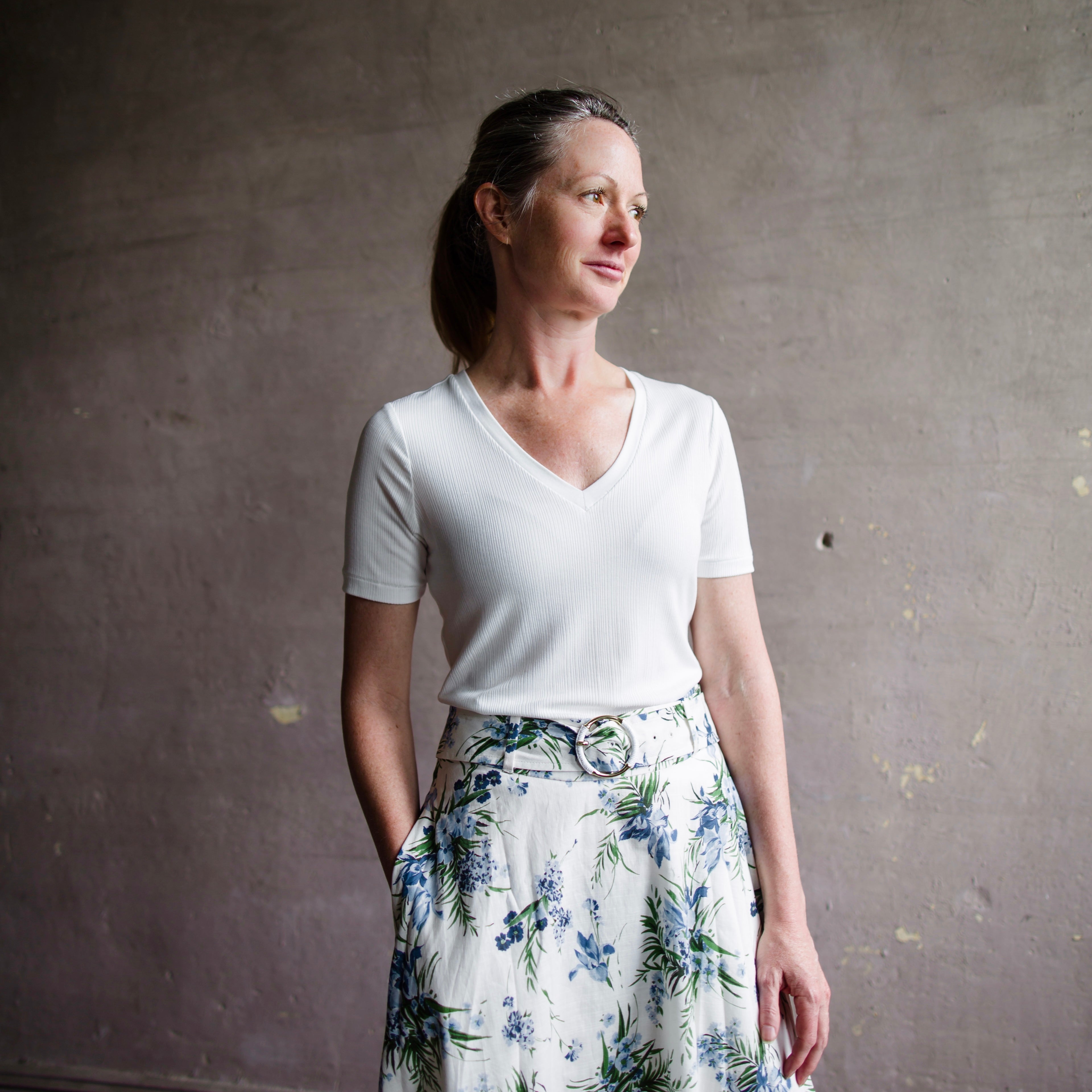 Image featuring a woman wearing the Rag & Bone Luca T-shirt with a rib-knit, V-neck and classic short sleeves in white.