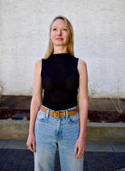 Woman wearing the Rag and Bone Molly Mock Neck black Top in semi-sheer knit construction and expertly designed minimalist silhouette