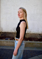 Woman wearing the Rag and Bone Molly Mock Neck black Top in semi-sheer knit sleeveless perfect for layering slim fitted