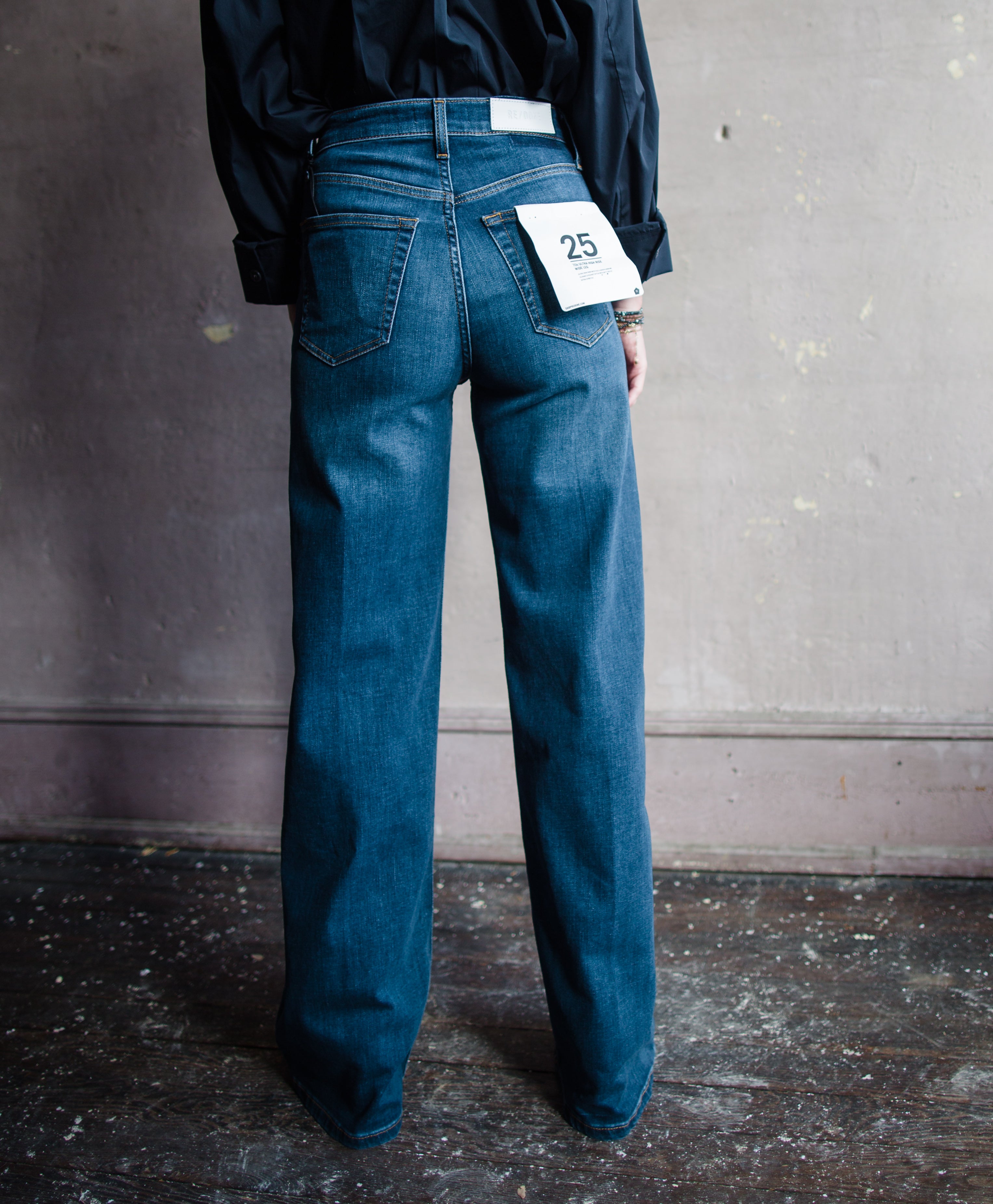 Image features woman wearing the 70's Ultra High Rise Wide Leg Jeans by Re/Done. Denim has a high rise and wide leg with a full length hem.